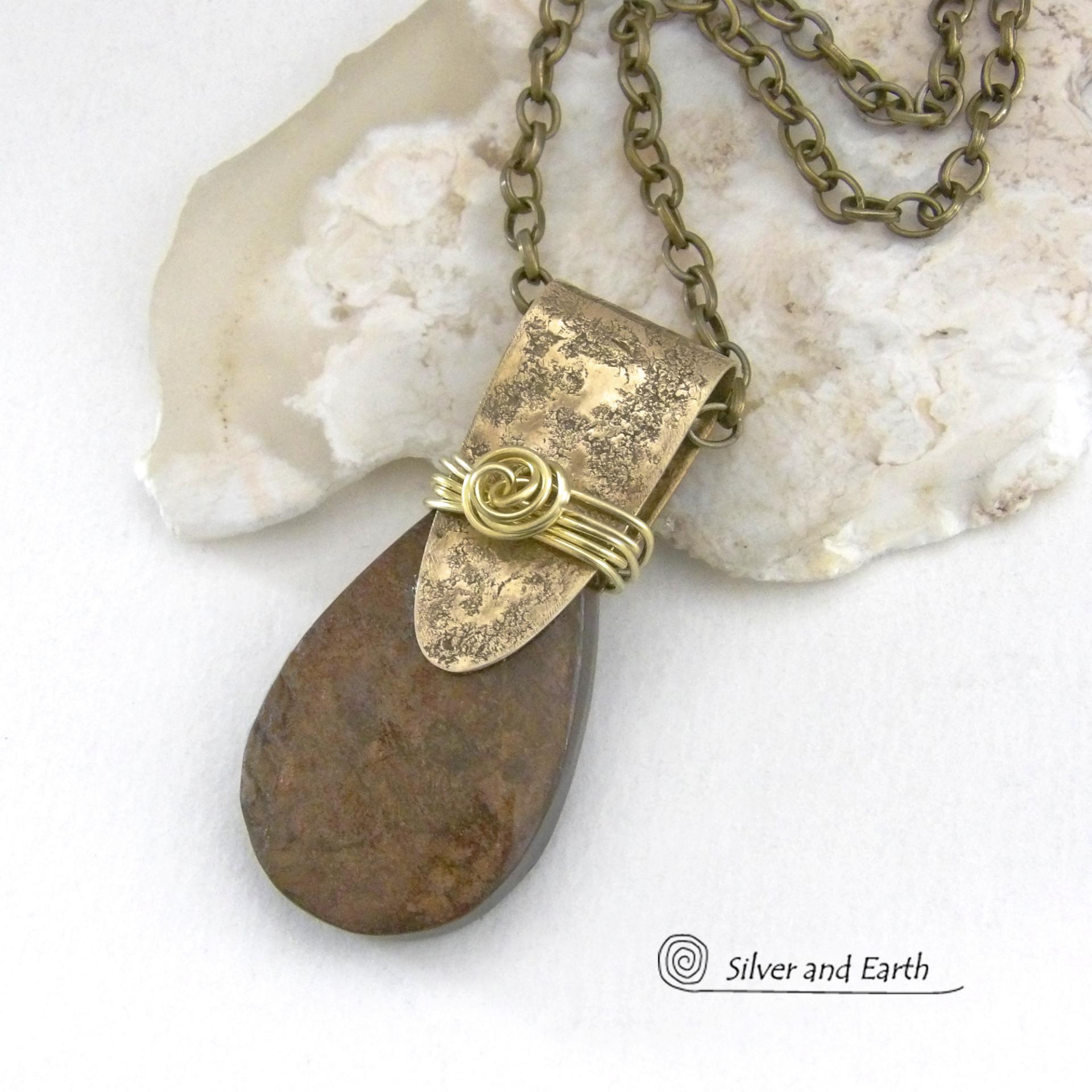 This handcrafted necklace features a natural bronzite gemstone accented with a gold brass bail. The stone has a beautiful chocolate brown hue with a subtle golden shimmer. Bronzite is a mineral that shares characteristics with rock that is found in meteorites, such as iron. It's this blend of several minerals which gives bronzite its unique mottled characteristic. The necklace has an earthy, modern style that coordinates beautifully with all wardrobe types. 