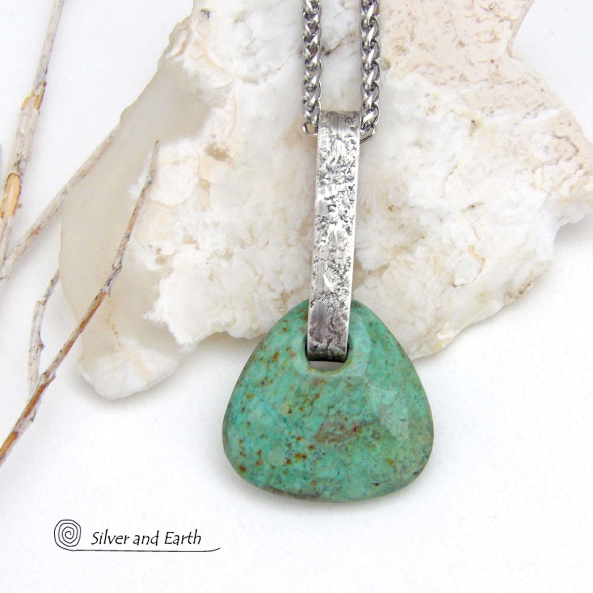 This one-of-a-kind pendant necklace features a beautiful chunky natural chrysocolla gemstone with a faceted finish. The stone is a beautiful shade of bluish-green which resembles turquoise. It hangs from a hand forged solid sterling silver bail with a lightly hammered organic texture. It's reversible. Unique and one-of-a-kind, it's sure to make a statement. Handmade in the USA by Silver and Earth Jewelry.