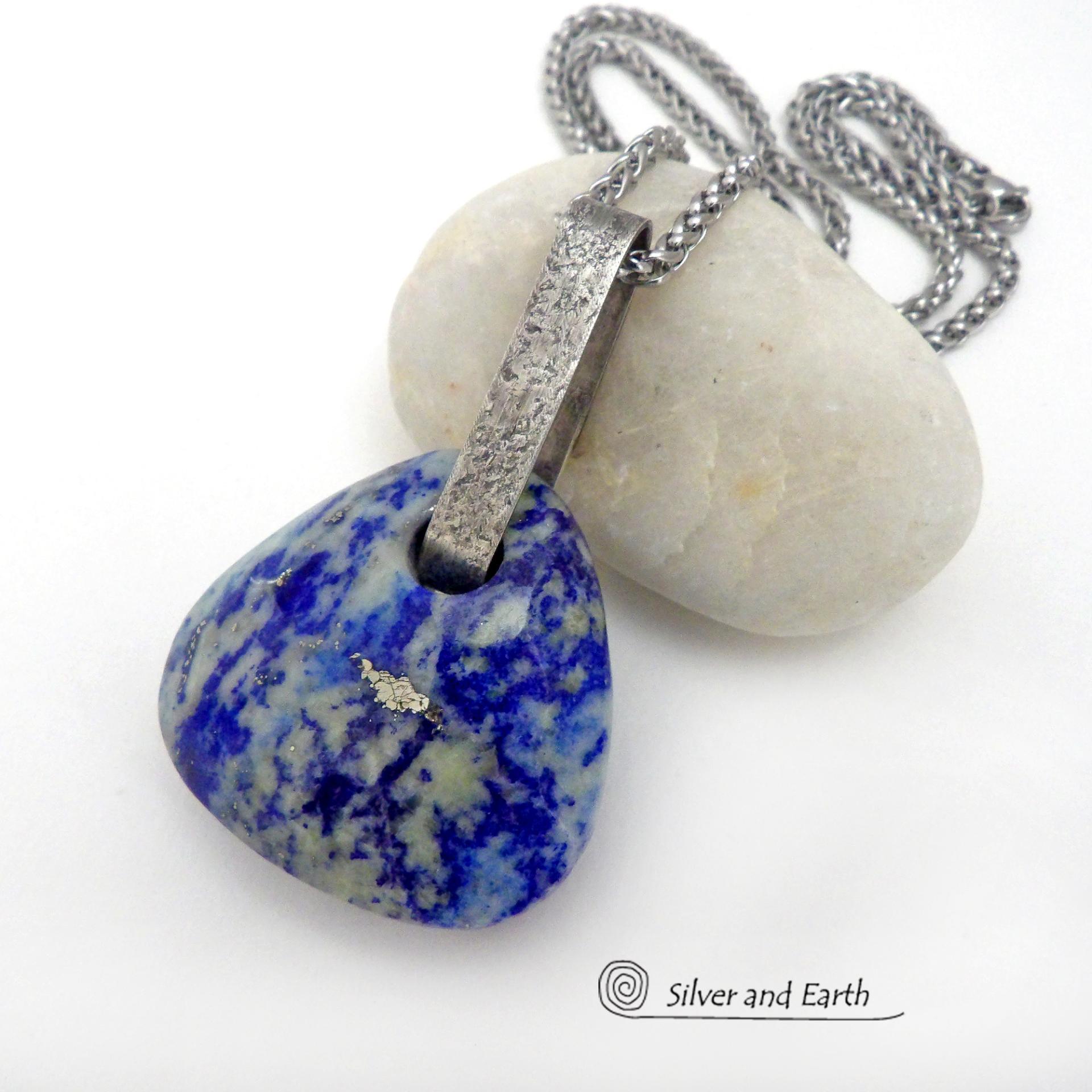 This one-of-a-kind necklace features a gorgeous, chunky and thick natural lapis lazuli gemstone accented with a handcrafted sterling silver bail with a lightly hammered organic texture. The stone is a beautiful shade of blue with white inclusions and a sprinkling of natural sparkly pyrite inclusions and a faceted finish. The stone is equally gorgeous on both sides, so I designed it to be reversible. (See all photos for alternate sides). Handmade in the USA by Silver and Earth Jewelry.