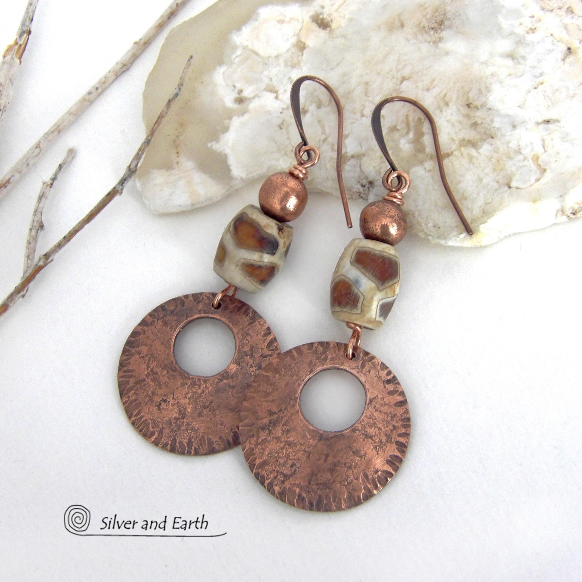 These handcrafted copper earrings have a bold, ethnic African style and flair. They feature round copper dangles with a rustic hammered texture accented with African etched giraffe print agate stones topped off with solid copper beads. Unique and striking, they'll make a bold statement. Perfect for women that love ethnic tribal style jewelry. Handmade in the USA by Silver and Earth Jewelry. 