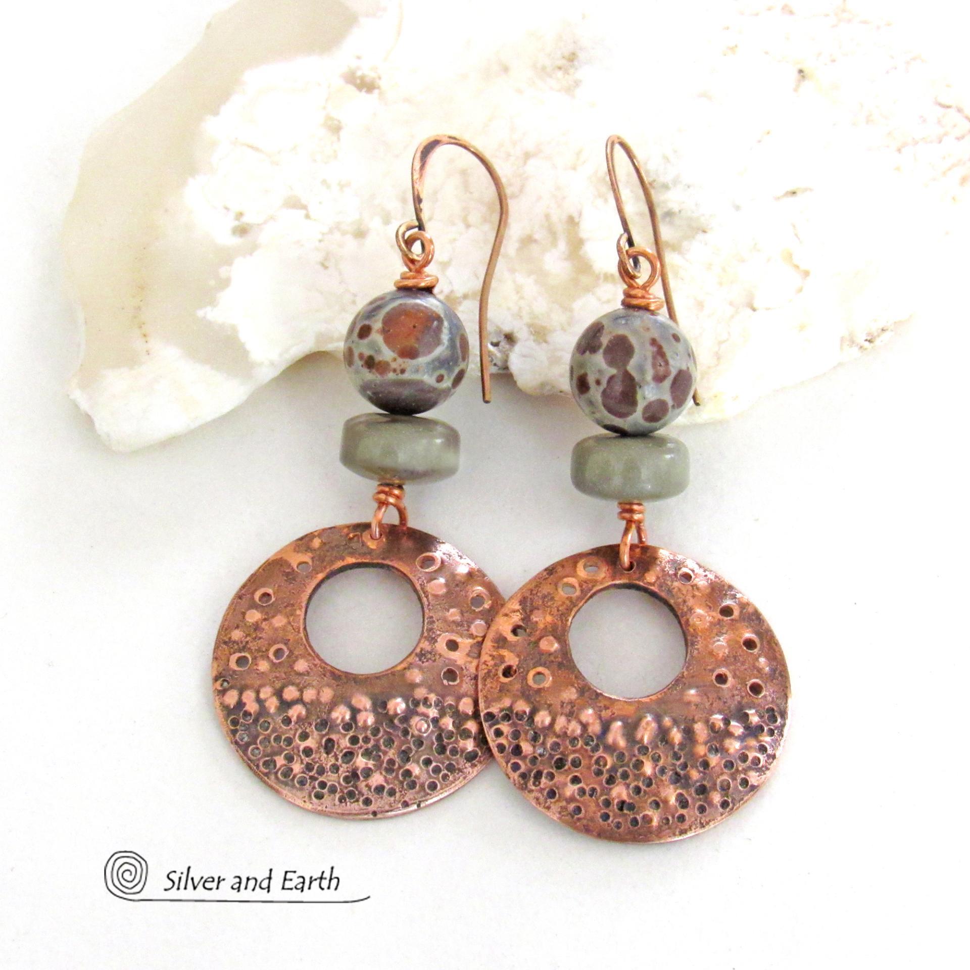 Handcrafted copper earrings with round copper hoop dangles with a rustic bumpy hammered texture accented with natural spotted asteroid jasper and gray jasper stone beads. Unique and striking, they have an earthy organic flair that makes a bold statement.