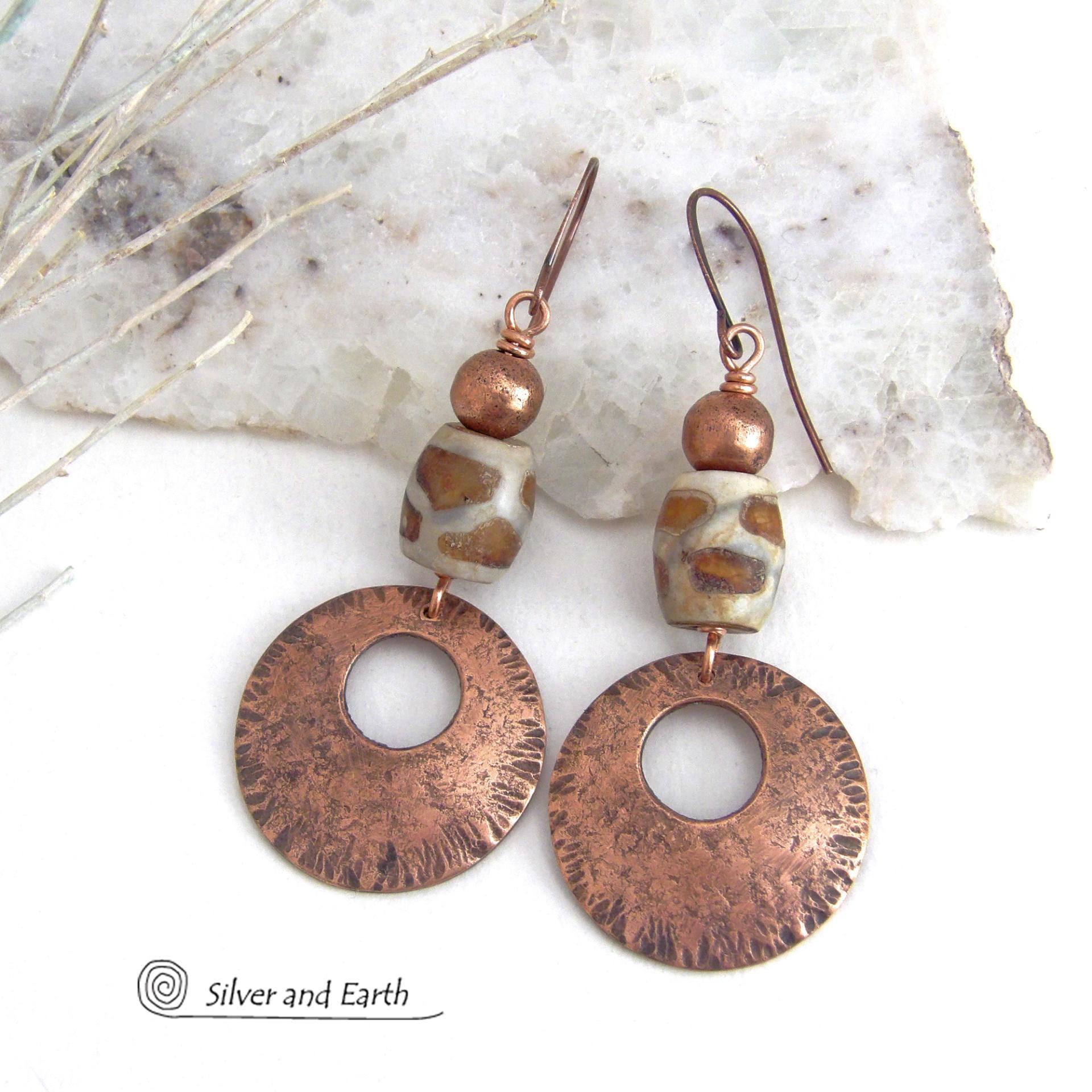 These handcrafted copper earrings have a bold, ethnic African style and flair. They feature round copper dangles with a rustic hammered texture accented with African etched giraffe print agate stones topped off with solid copper beads. Unique and striking, they'll make a bold statement. Perfect for women that love ethnic tribal style jewelry. Your choice of ear wire - copper or hypoallergenic niobium.