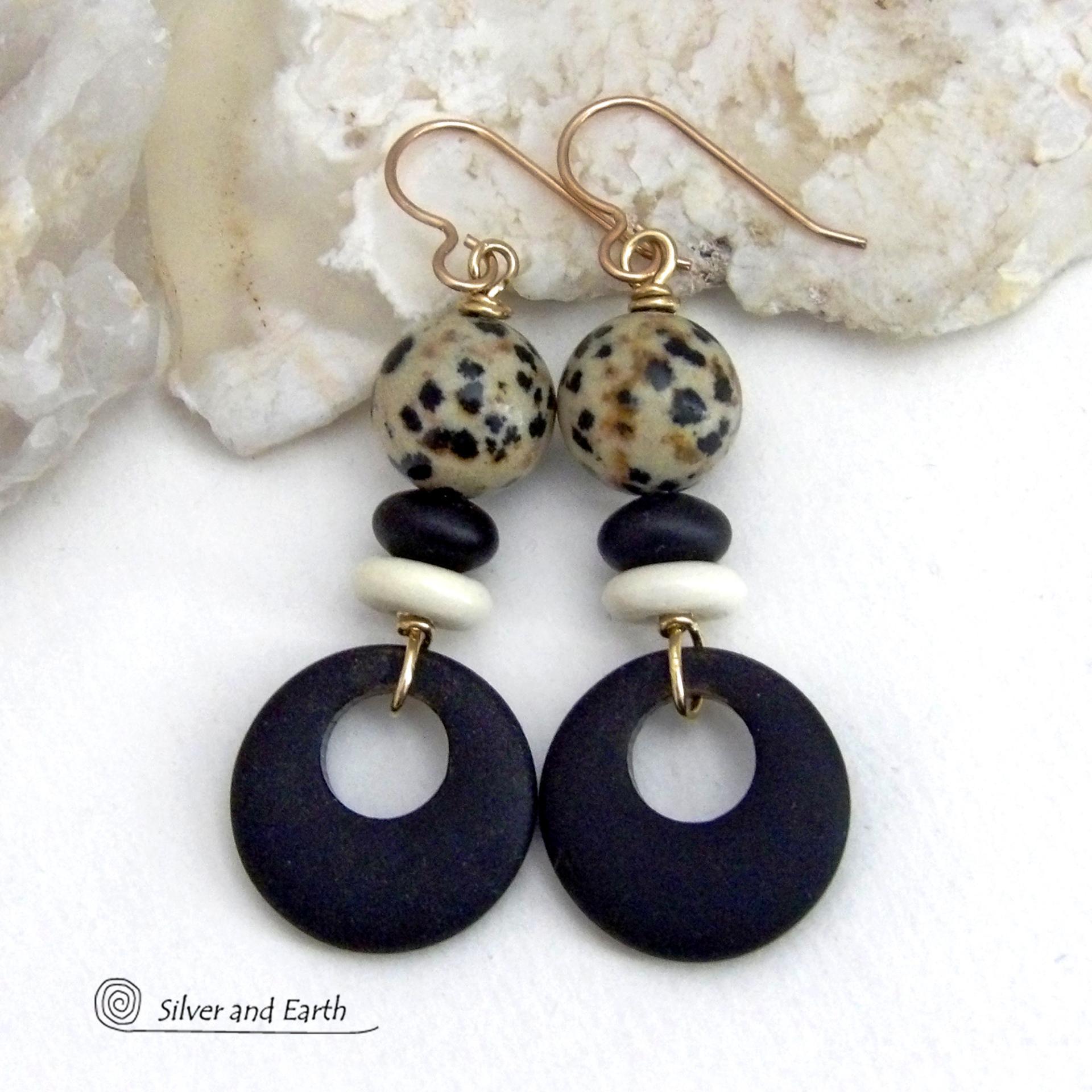 These handcrafted earrings feature matte black glass circle hoops accented with Dalmatian jasper gemstones, African bone and black glass beads. Unique and fun to wear, they have an earthy natural style with boho chic flair that makes a striking statement. They'll make a great gift for a natural stone lover - or a nice addition to your own jewelry wardrobe. Handmade in the USA by Silver and Earth Jewelry. 