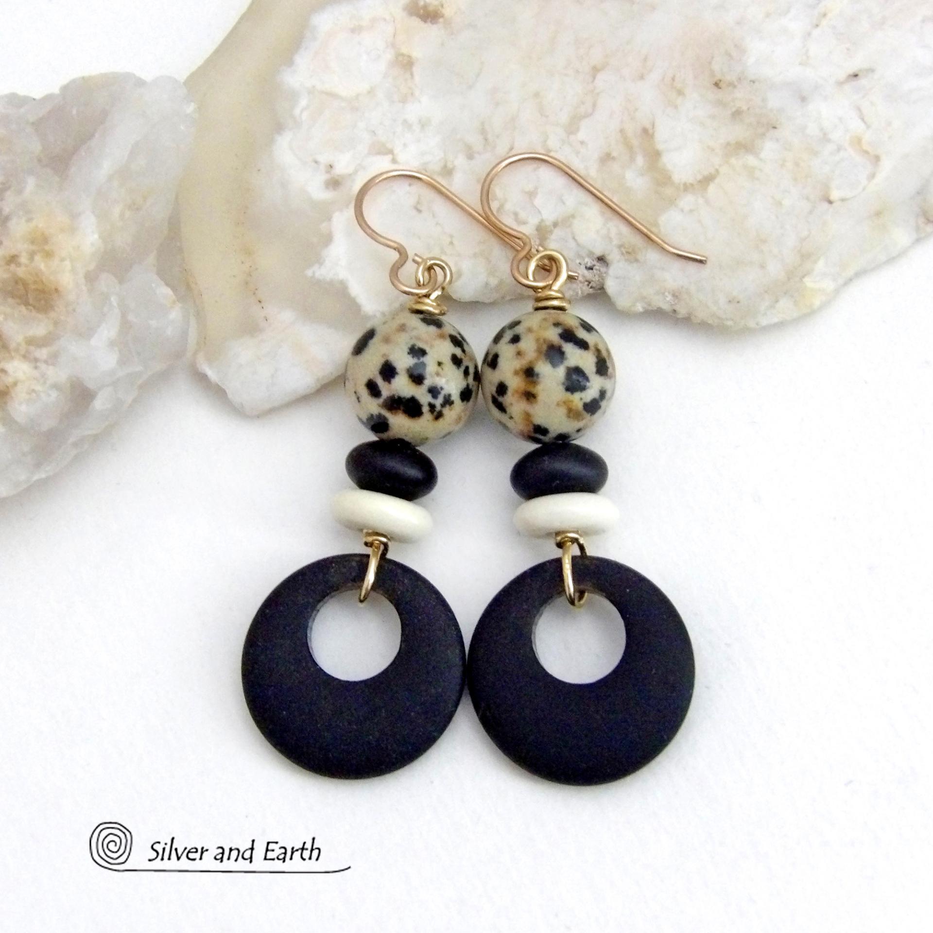 These handcrafted earrings feature matte black glass circle hoops accented with Dalmatian jasper gemstones, African bone and black glass beads. Unique and fun to wear, they have an earthy natural style with boho chic flair that makes a striking statement. They'll make a great gift for a natural stone lover - or a nice addition to your own jewelry wardrobe. Handmade in the USA by Silver and Earth Jewelry. 
