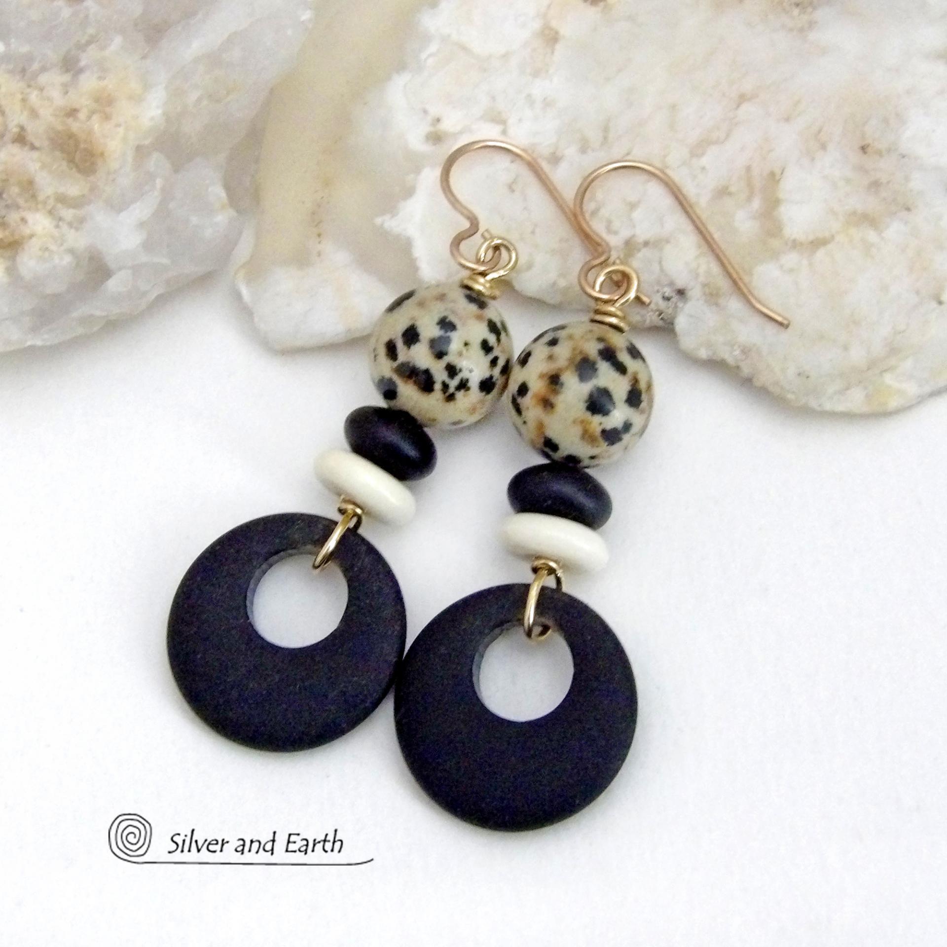 These handcrafted earrings feature matte black glass circle hoops accented with Dalmatian jasper gemstones, African bone and black glass beads. Unique and fun to wear, they have an earthy natural style with boho chic flair that makes a striking statement. They'll make a great gift for a natural stone lover - or a nice addition to your own jewelry wardrobe. Handmade in the USA by Silver and Earth Jewelry. 