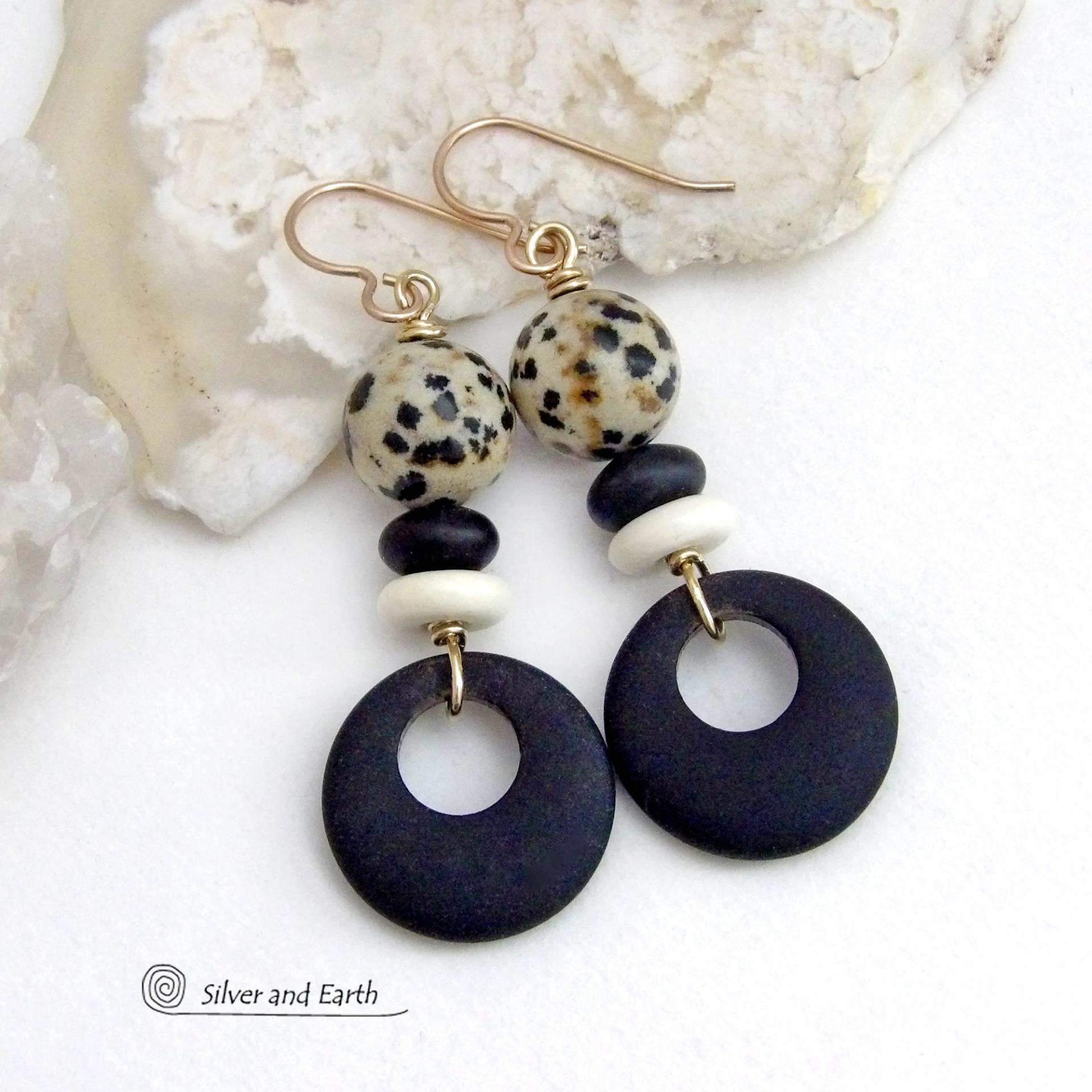 These handcrafted earrings feature matte black glass circle hoops accented with Dalmatian jasper gemstones, African bone and black glass beads. Unique and fun to wear, they have an earthy natural style with boho chic flair that makes a striking statement. They'll make a great gift for a natural stone lover - or a nice addition to your own jewelry wardrobe. Handmade in the USA by Silver and Earth Jewelry. 