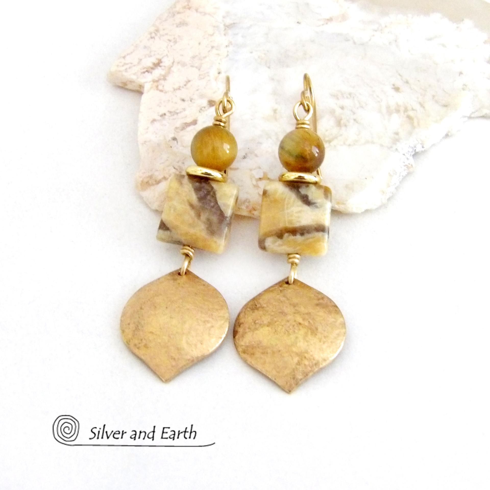 These handcrafted earrings feature shiny gold brass dangles with a hammered raw silk texture accented with graphic feldspar and golden tiger's eye gemstones and shiny brass beads. Graphic feldspar is a type of moonstone that has smoky quartz inclusions which creates unique natural patterns. They have an elegant, modern chic style that looks great dressed up or down. 