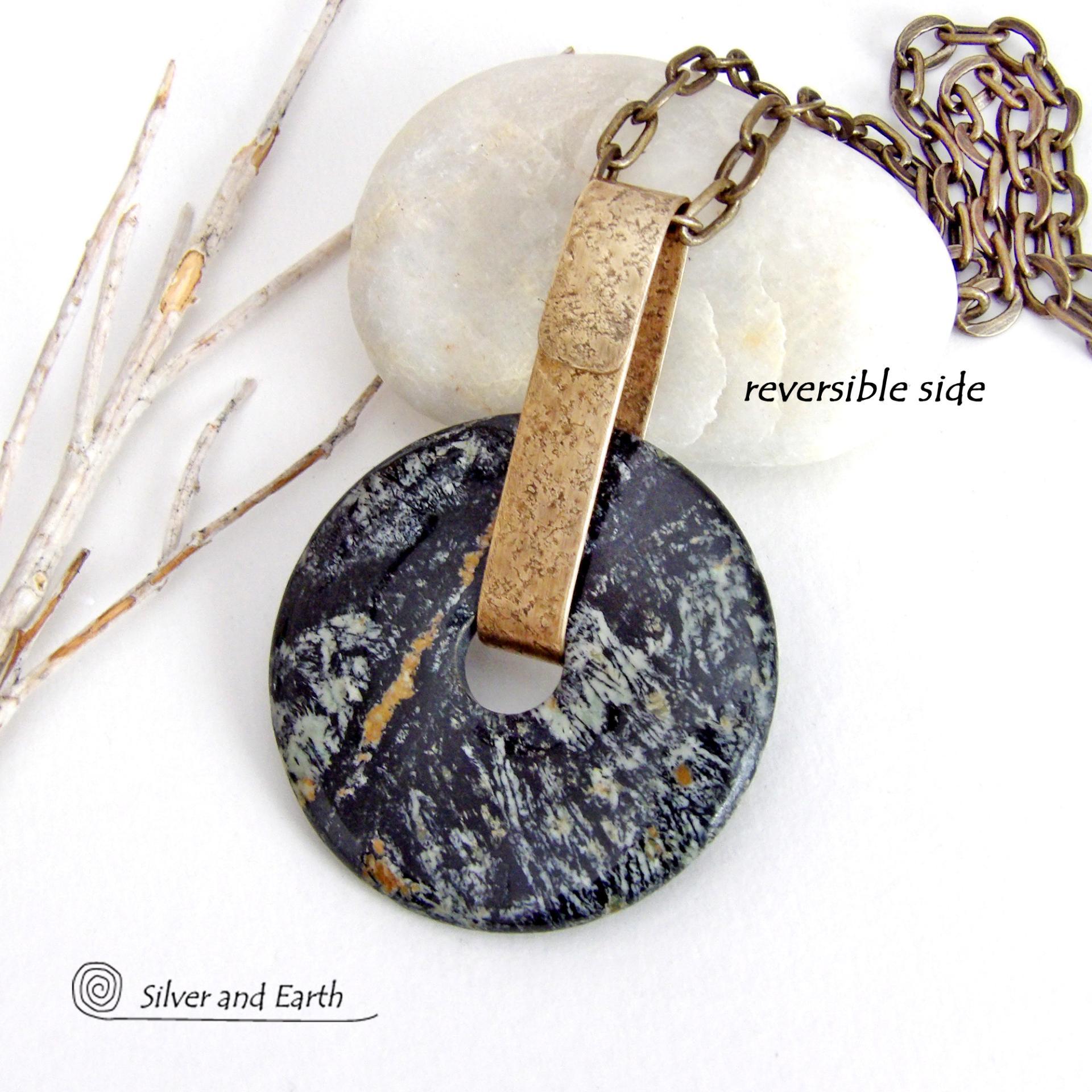 This one-of-a-kind pendant necklace has a large stunning fireworks jasper stone accented with a hand forged gold brass bail. The stone has a natural bold dramatic pattern in hues of black, gold, mint green and cream. The design is modern and bold - yet classic and always in fashion. It can be worn by either a man or women. It's reversible and can be worn on either side. Makes a great gift for a natural stone lover. Handmade in the USA by Silver and Earth Jewelry.