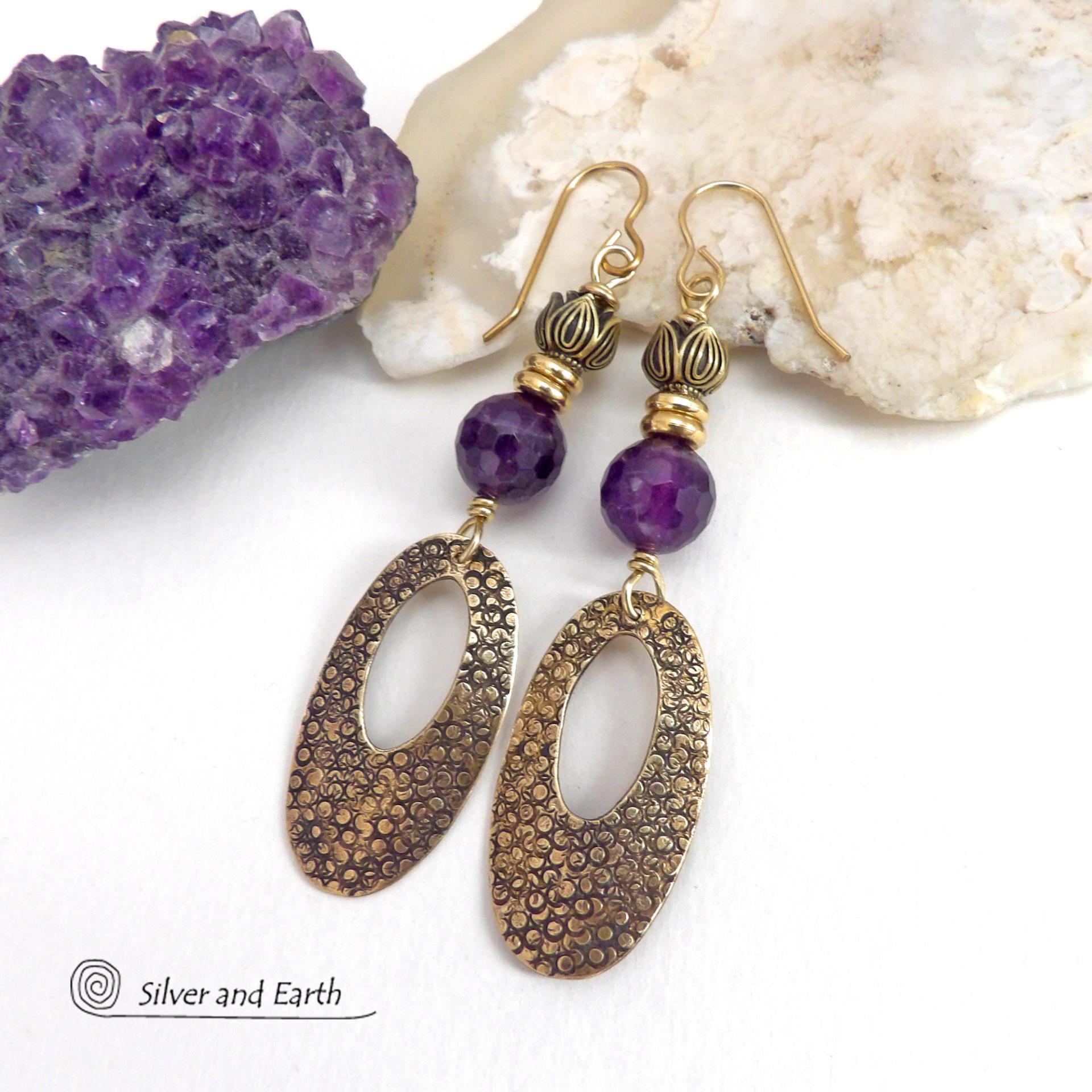 These handcrafted gold brass earrings have a hand stamped texture and are accented with faceted purple amethyst gemstones, tiny brass beads and tulip flower-shaped beads. Exotic and unique, they have an elegant chic Egyptian style vibe that makes a bold statement. They'll make a great gift for someone born in February - Amethyst is February's birthstone. Handmade in the USA by Silver and Earth Jewelry. 