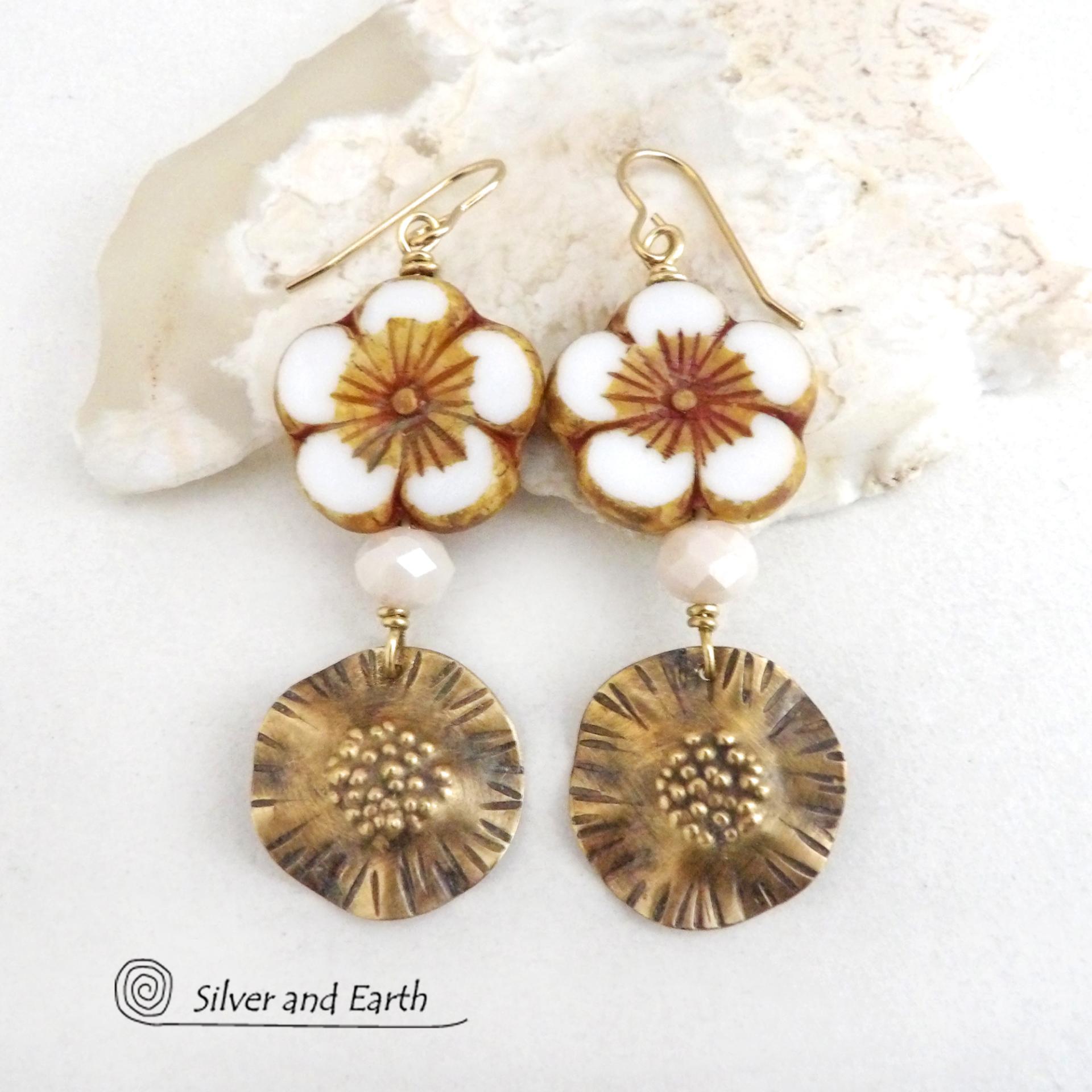 These handcrafted earrings feature large stunning white glass flower beads with golden highlights accented with gold brass dangles with a hand textured design and white faceted crystal beads which add sparkle and shine. They have an elegant, modern chic style and will make a great gift for anyone that loves flowers and nature. Perfect for your spring / summer wardrobe -- or any time of year. 