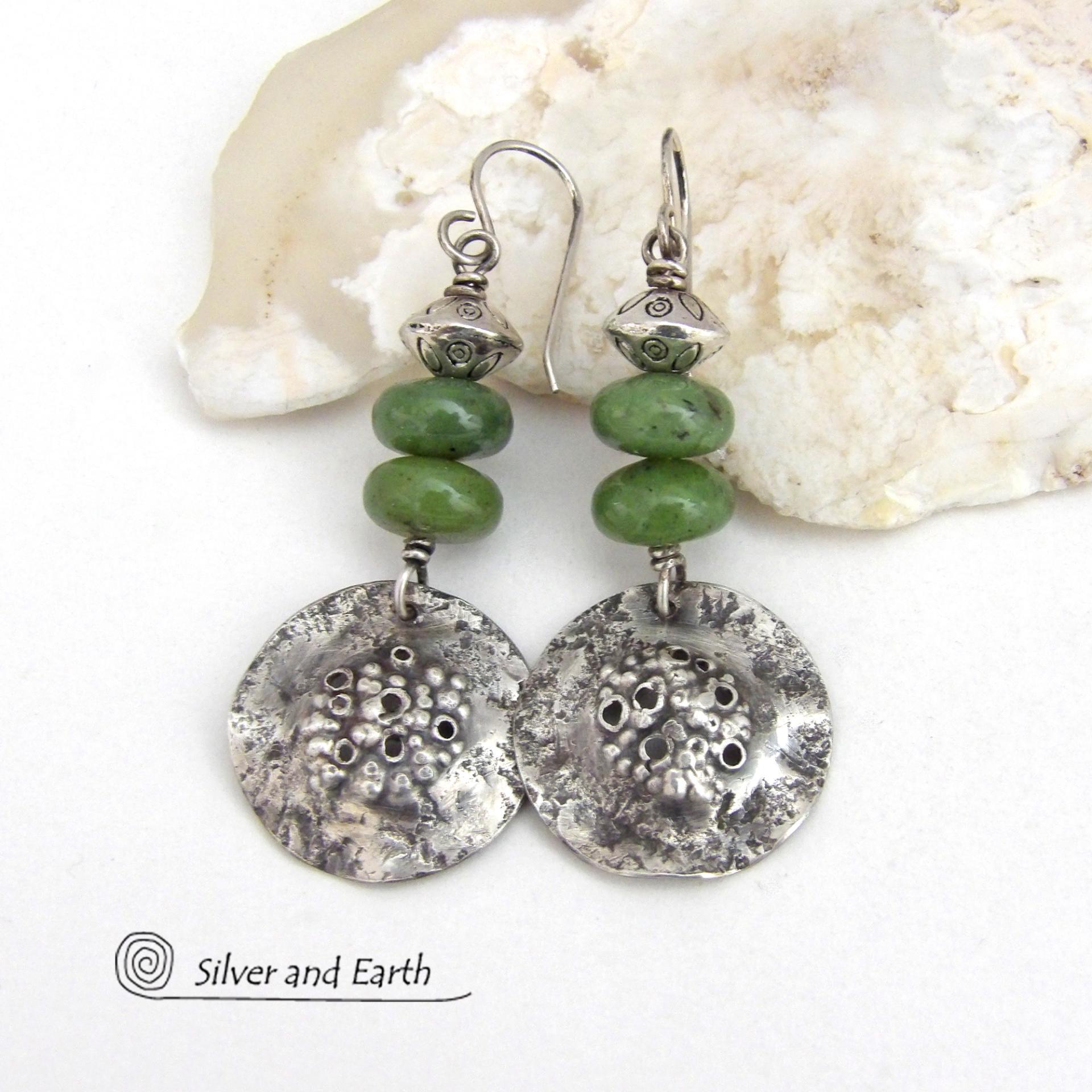 These handcrafted earrings feature textured sterling silver dangles accented with a stack of Canadian green jade gemstones topped off with silver pewter beads. The silver has a hammered rustic organic texture, along with a few holes that were added for a primal effect. They have an earthy, modern style that coordinates well with all wardrobe types. 