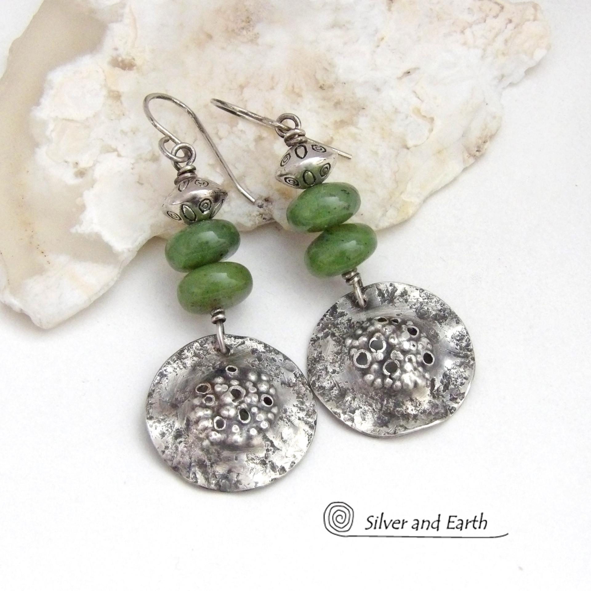 These handcrafted earrings feature textured sterling silver dangles accented with a stack of Canadian green jade gemstones topped off with silver pewter beads. The silver has a hammered rustic organic texture, along with a few holes that were added for a primal effect. They have an earthy, modern style that coordinates well with all wardrobe types. 