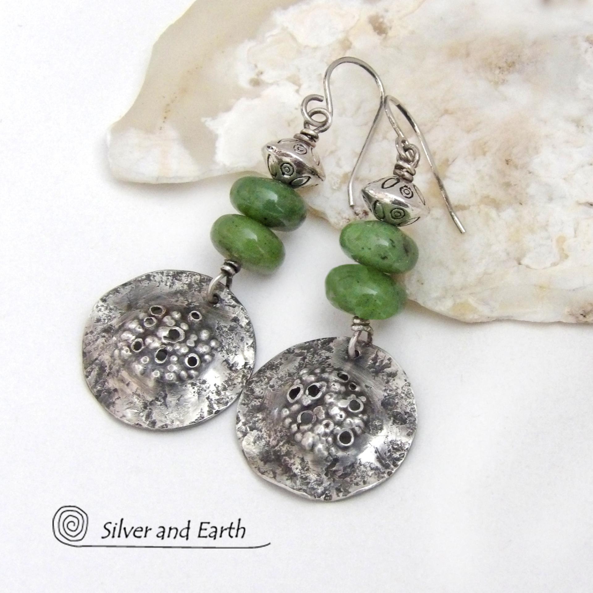 These handcrafted earrings feature textured sterling silver dangles accented with a stack of Canadian green jade gemstones topped off with silver pewter beads. The silver has a hammered rustic organic texture, along with a few holes that were added for a primal effect. They have an earthy, modern style that coordinates well with all wardrobe types. 