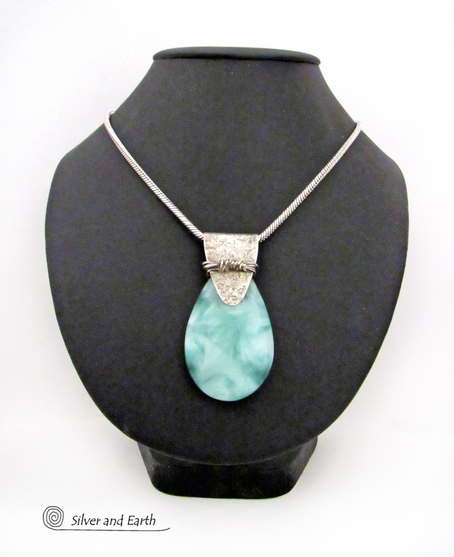 A stunning, natural green moonstone is accented with a handcrafted sterling silver bail in this one-of-a-kind pendant necklace. The stone has a beautiful mint green hue with a creamy white matrix. The bail is accented with twists of oxidized sterling silver wire. Bold and unique, it's sure to make a striking statement. 
