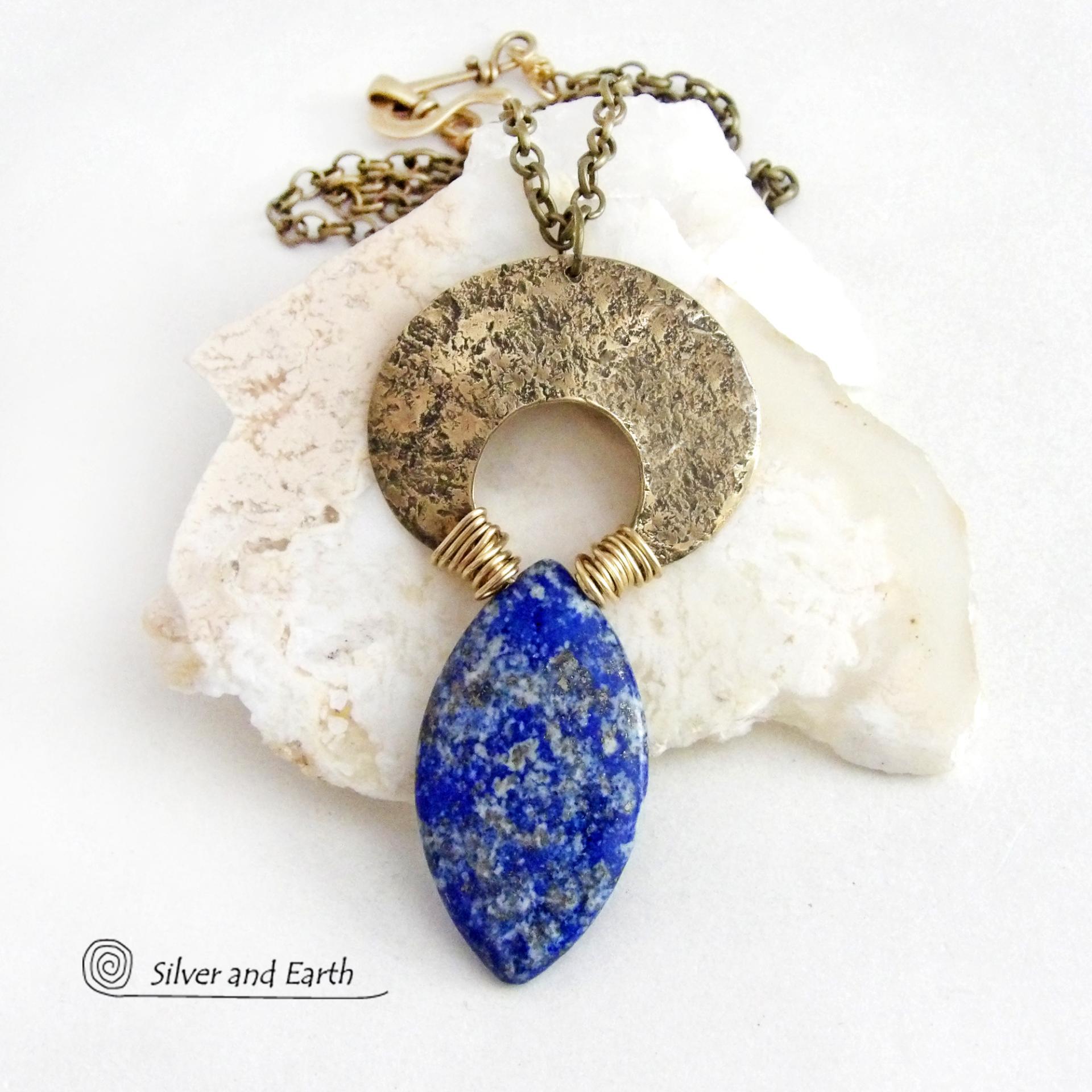 A stunning natural lapis lazuli gemstone is accented with a handcrafted gold brass crescent moon in this bold exotic necklace. The stone has a beautiful blue hue with a natural matrix of white and silvery pyrite inclusions. Unique and one-of-a-kind, it has an "Old World" Egyptian style and flair that makes a striking statement.