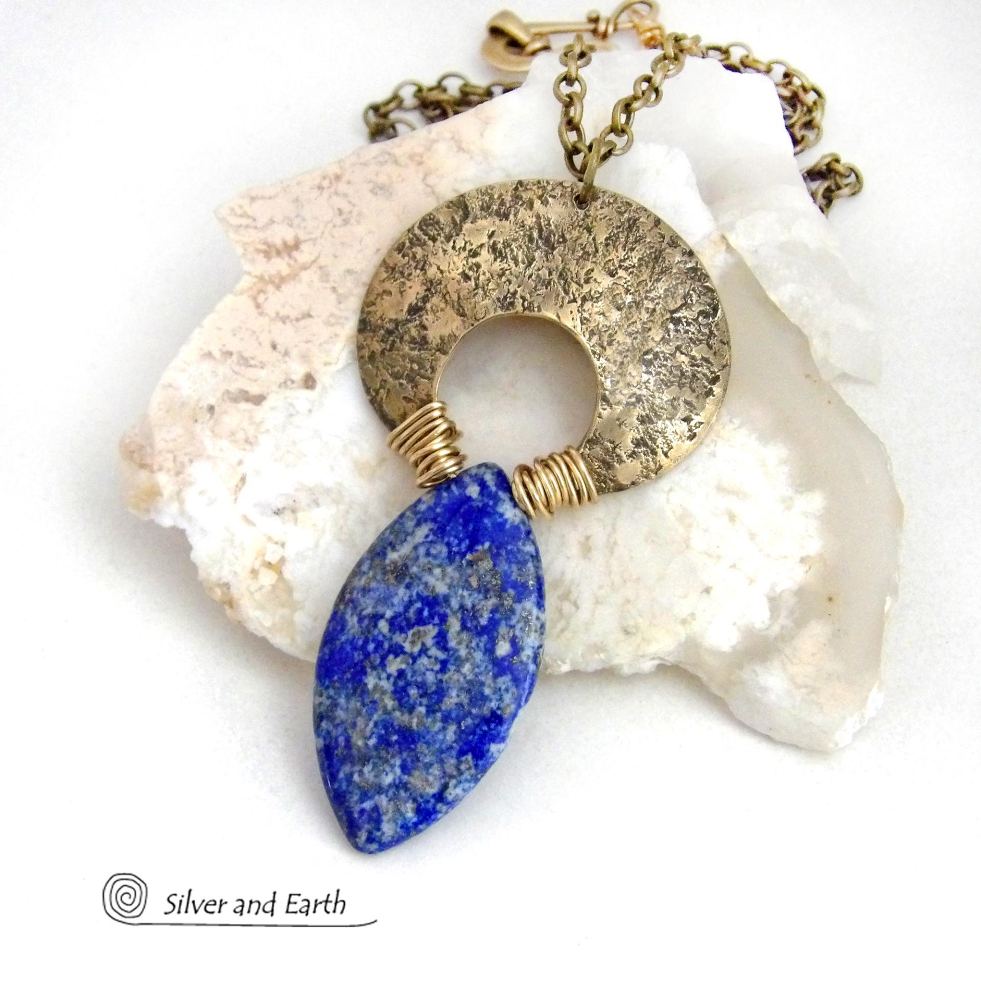 A stunning natural lapis lazuli gemstone is accented with a handcrafted gold brass crescent moon in this bold exotic necklace. The stone has a beautiful blue hue with a natural matrix of white and silvery pyrite inclusions. Unique and one-of-a-kind, it has an "Old World" Egyptian style and flair that makes a striking statement.