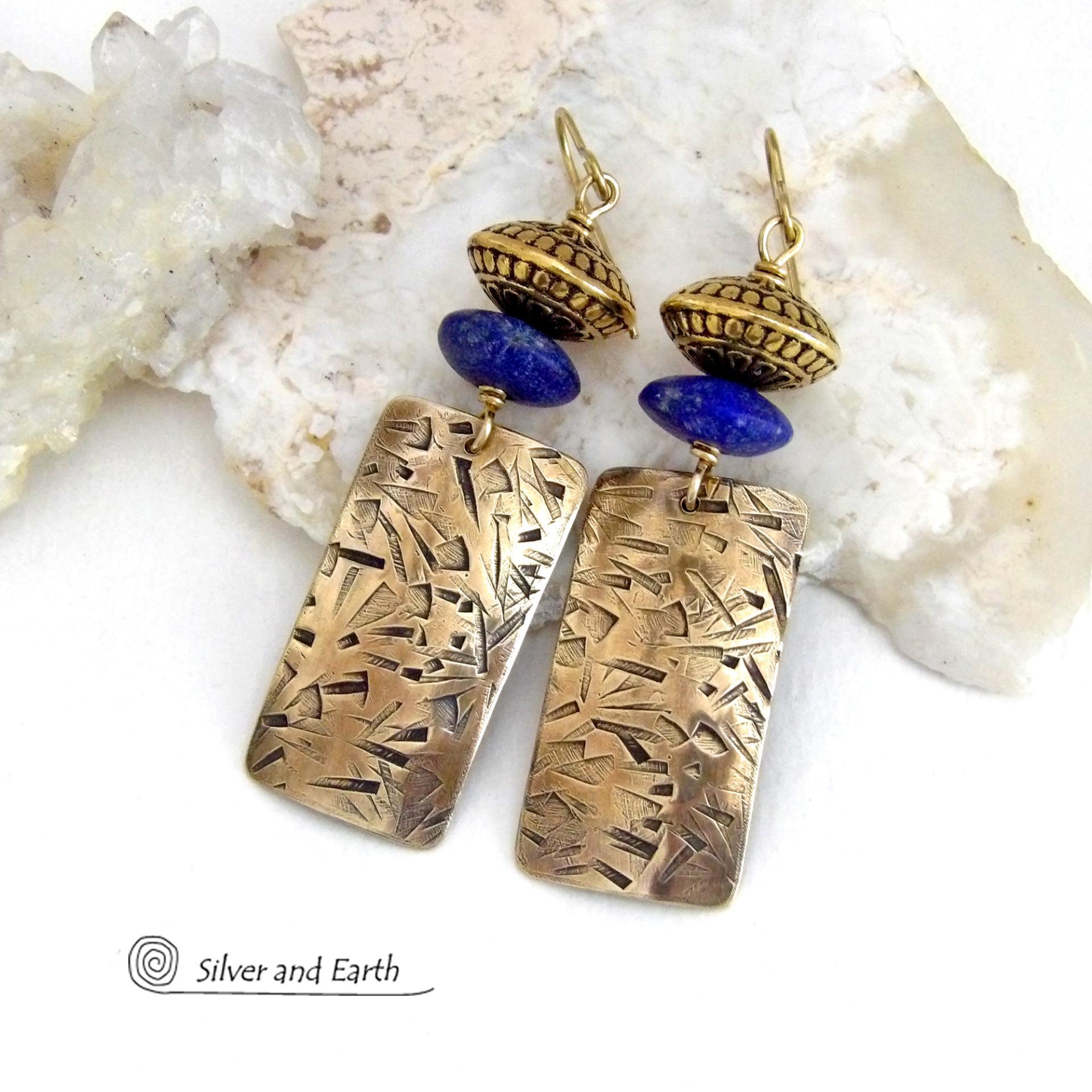 These earrings feature handcrafted brass rectangle dangles with a hand stamped texture accented with matte lapis lazuli gemstones and brass tribal style beads. They have an elegant modern style with boho chic flair that coordinates beautifully with all wardrobe styles. Perfect for women that love to wear unique artisan handcrafted jewelry. Handmade in the USA by Silver and Earth Jewelry.