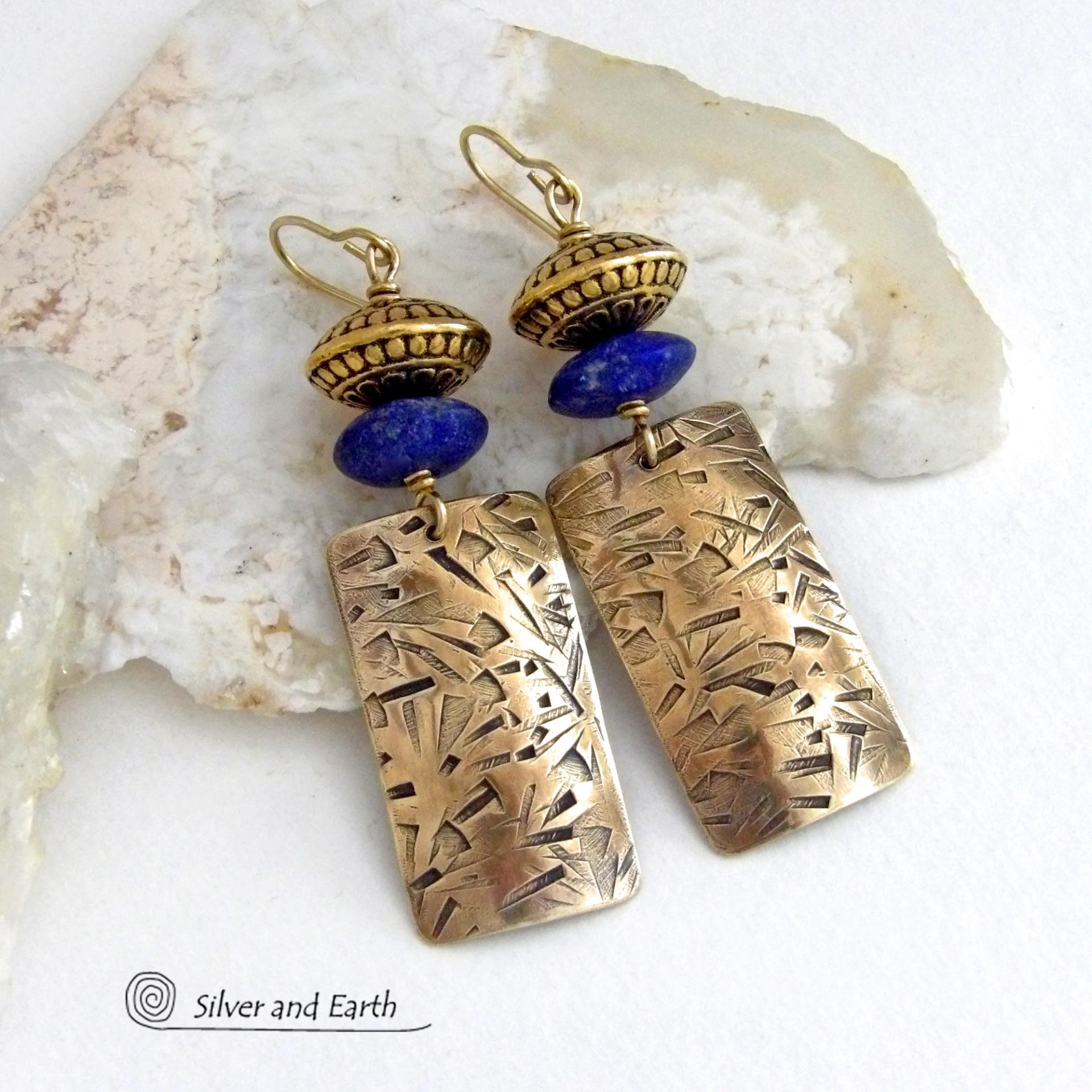 These earrings feature handcrafted brass rectangle dangles with a hand stamped texture accented with matte lapis lazuli gemstones and brass tribal style beads. They have an elegant modern style with boho chic flair that coordinates beautifully with all wardrobe styles. Perfect for women that love to wear unique artisan handcrafted jewelry. Handmade in the USA by Silver and Earth Jewelry.