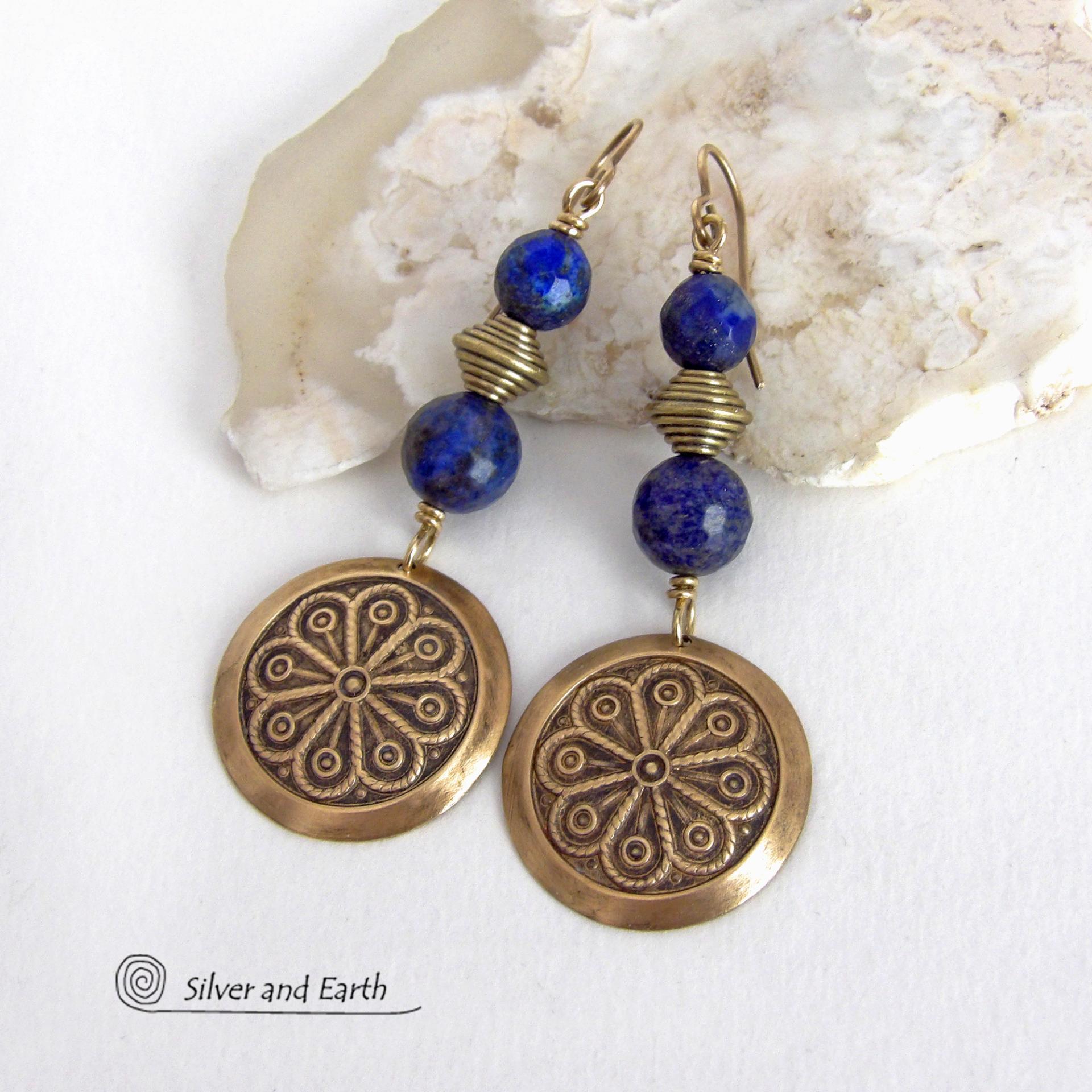 These handcrafted gold brass earrings have an exotic, Egyptian inspired vibe. They feature brass circle dangles with a beautiful embossed texture accented with faceted genuine lapis lazuli gemstones and textured brass beads. Bold and unique, they'll add a touch of cultural exotic charm to any type of wardrobe - dressed up or down. Perfect for women that love unique artisan handcrafted jewelry. Handmade in the USA by Silver and Earth Jewelry. 