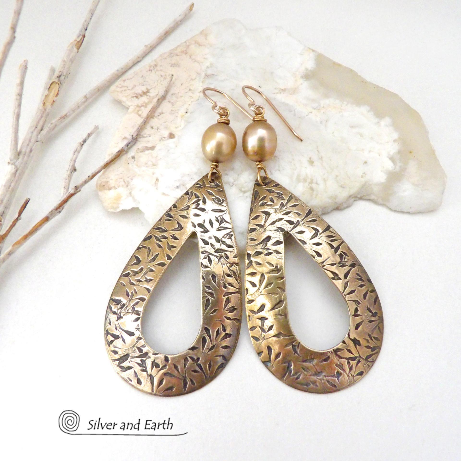 These gold brass hoop earrings have an intricate hand stamped texture and are accented with gold freshwater pearls. Big and bold, they're sure to make a statement! Long and dramatic - yet surprisingly lightweight to wear - despite their impressive appearance.