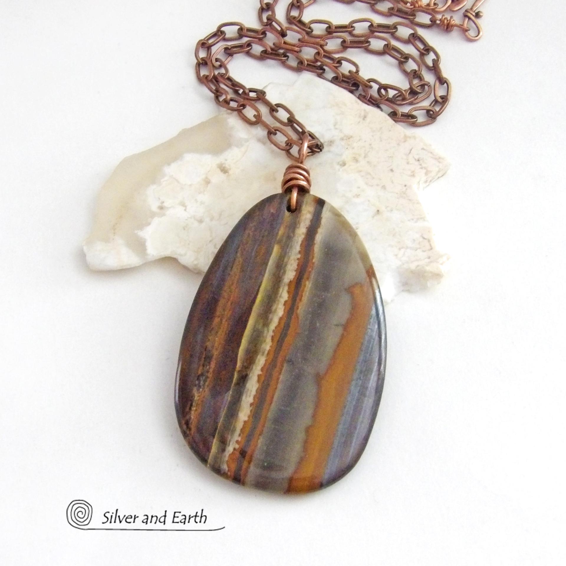 Big and bold, this one of a kind pendant necklace features a large natural tiger iron gemstone with a copper wire bail. The stone has beautiful earthy hues of various shades of brown, smoky grey, rust and creamy bands of white. It's a gorgeous stone with a nice high polish. Sure to make a striking statement, it'll make a great gift for a natural stone lover.