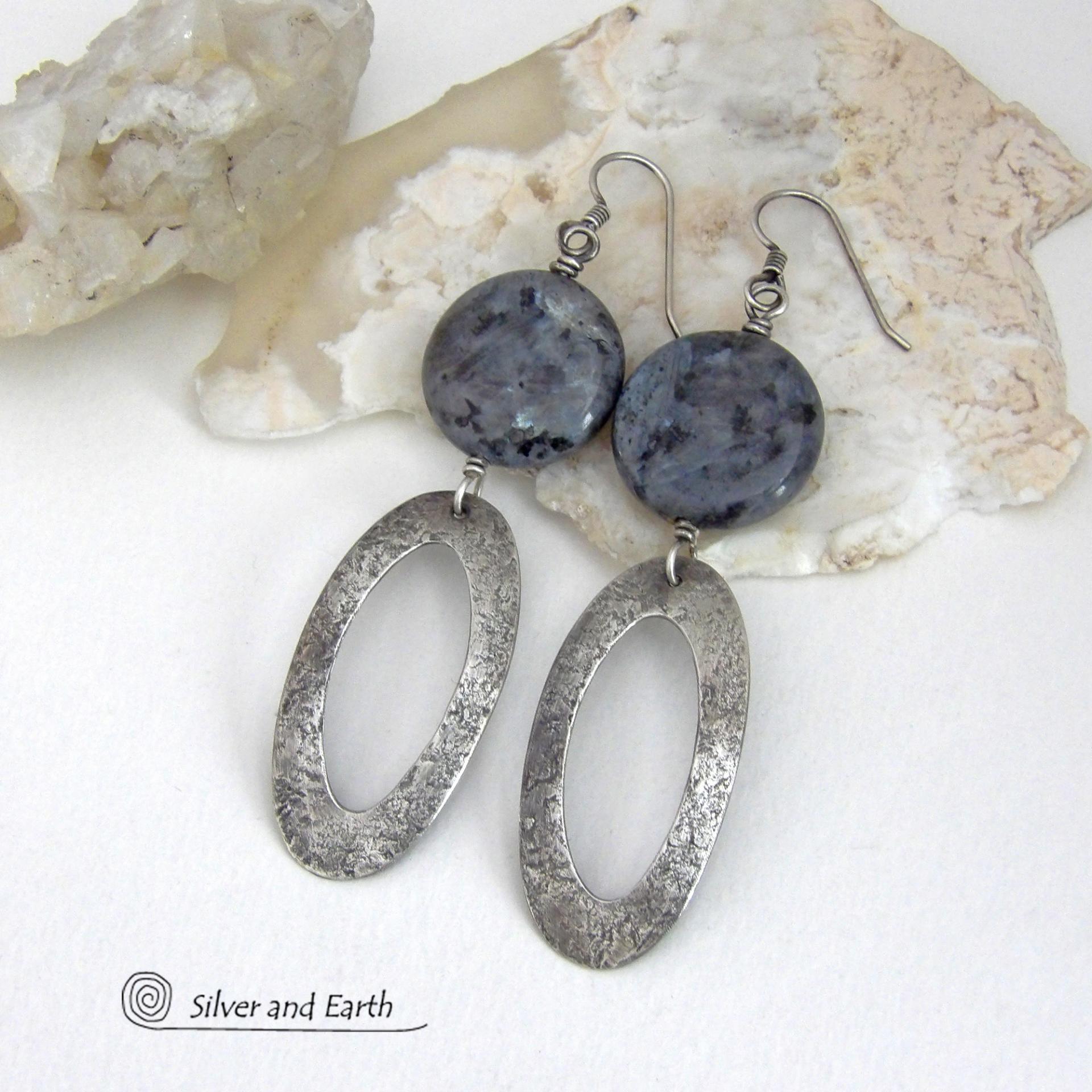 Modern, earthy & chic - these earrings feature big round natural larvikite gemstones accented with long sterling silver hoop dangles. The stones have a pearly, grayish black hue - along with blue iridescent flashes of light which cast off a natural shimmer & shine. They have a modern, contemporary style that coordinates beautifully with all wardrobe types. Larvikite originates from the Larvik region in Norway and is also called Norwegian moonstone and black labradorite. 