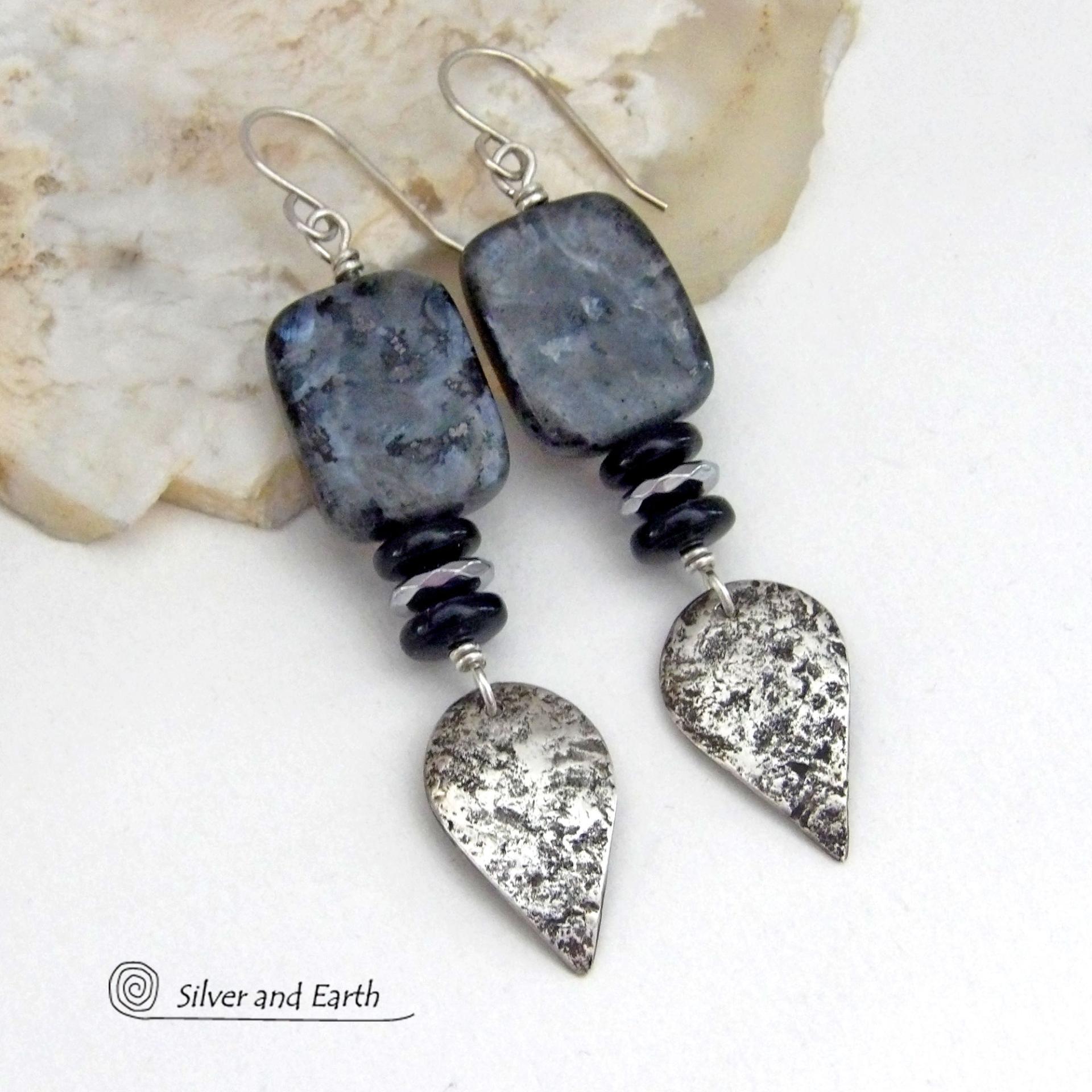 These handcrafted sterling silver earrings feature natural larvikite gemstones accented with small sterling silver dangles, black onyx and faceted silver hematite gemstones. The larvikite has a pearly, grayish black hue with iridescent flashes of light which cast off a natural shimmer & shine. They have a modern, chic contemporary style that will look great dressed up or down. Larvikite originates from the Larvik region in Norway. It's also called Norwegian moonstone and black labradorite.