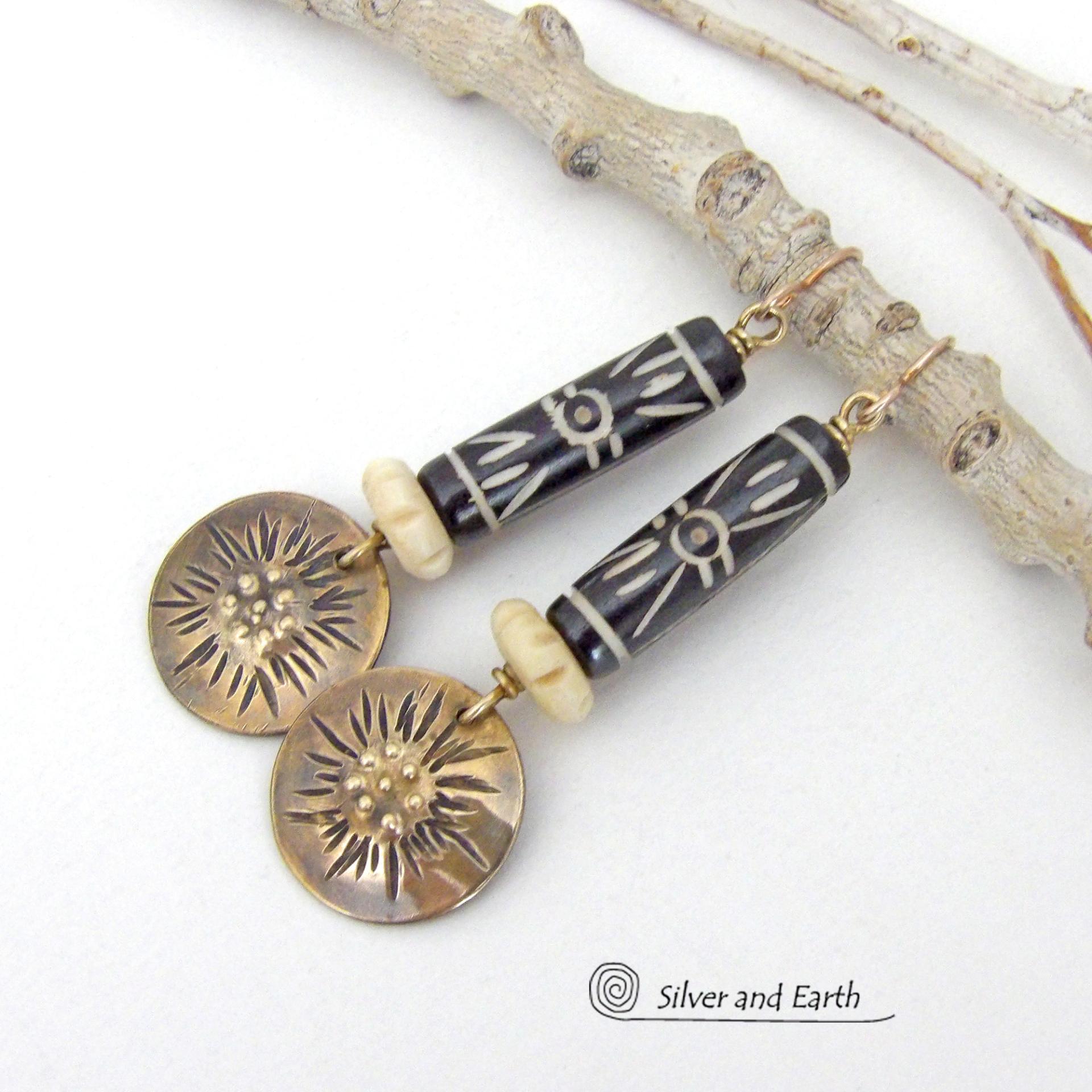 These handcrafted earrings feature African batik carved bone beads accented with textured gold brass dangles and carved bone beads. They have a boho chic tribal flair that will make a striking statement. Perfect for women that love to wear bold unique jewelry. Handmade in the USA by Silver and Earth Jewelry. 