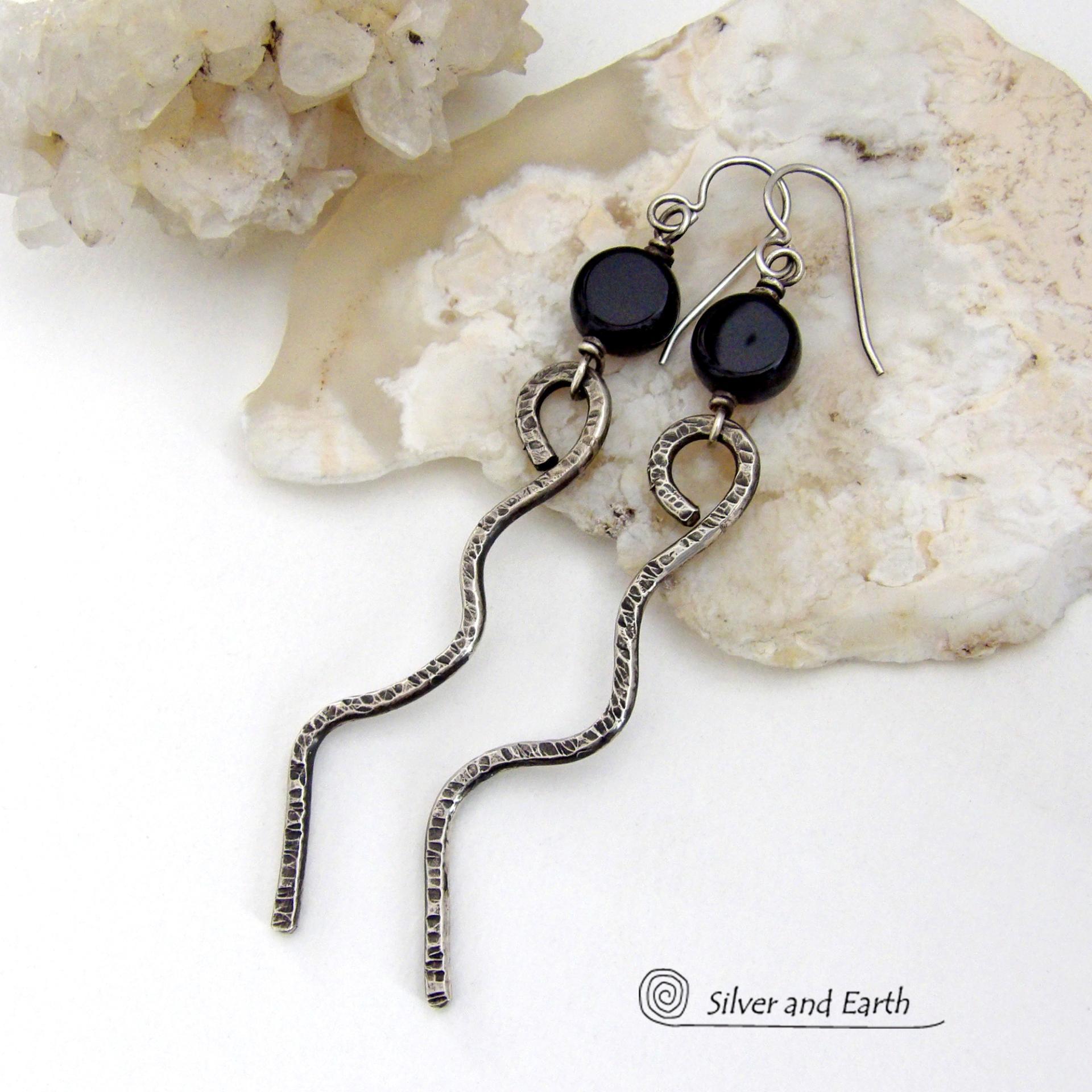 These handcrafted earrings have a contemporary modern and minimalist vibe. They feature hand forged solid sterling silver curvy sticks with a hammered organic texture topped off with coin-shaped black onyx gemstones.  Lightweight and fun to wear, they'll coordinate with all wardrobe styles and make a unique statement. Total length of approximately 3-1/4" from top of sterling silver ear wires and 3/8” at widest point of stone.