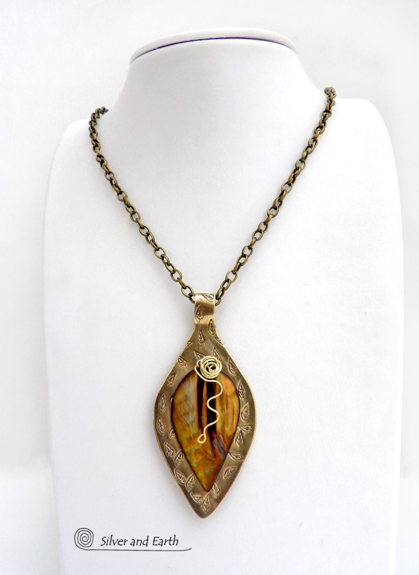This necklace features a golden brown carved Mother of Pearl leaf accented against a handcrafted gold brass base. I hand sawed the base out of solid gold brass sheet and stamped the metal with a leaf pattern to "echo" the Mother of Pearl leaf. Unique and one-of-kind, it'll make a great gift for a nature lover - or a nice addition to your own jewelry wardrobe. It comes on an 18" antiqued brass chain with lobster claw closure. Handmade in the USA by Silver and Earth Jewelry. 