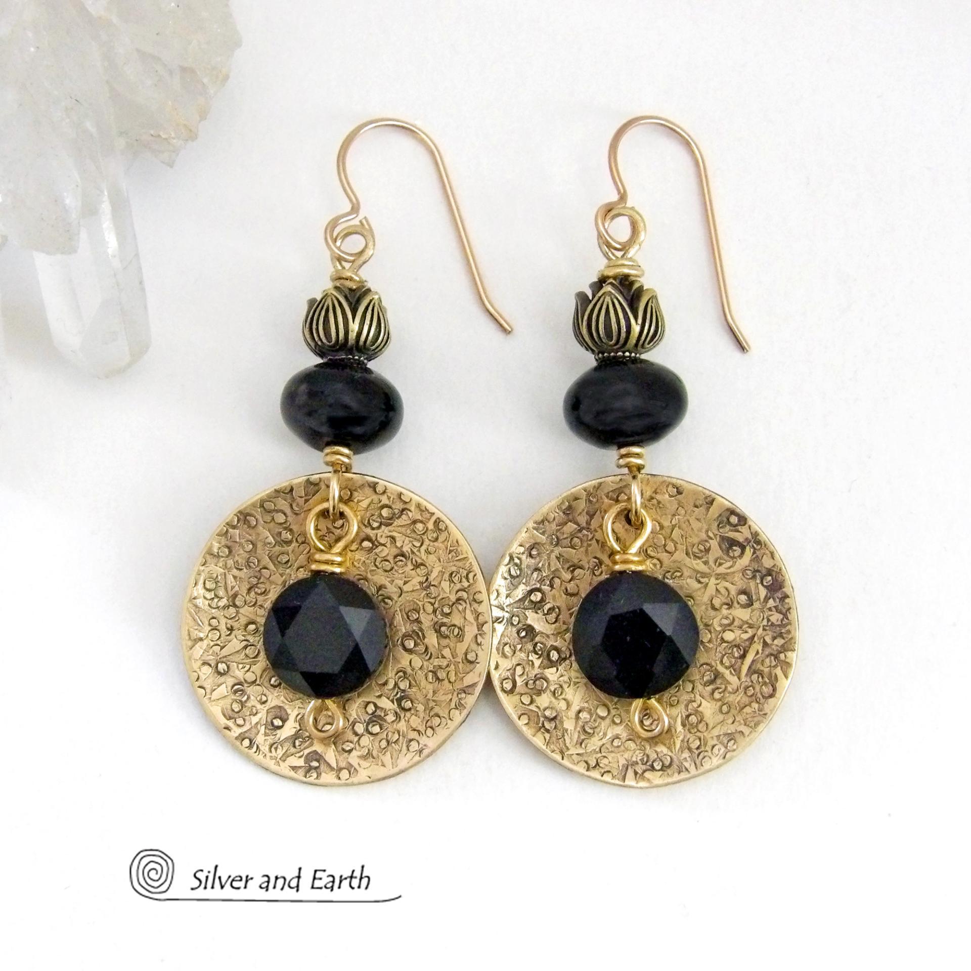 These handcrafted earrings feature gold brass dangles with a hand stamped texture accented with round black onyx gemstones dangling in front and topped off with black onyx gemstones and tulip flower-shaped beads. They have a modern, elegant chic style that looks great dressed up or down. Perfect for women that love bold unique artisan handcrafted jewelry. They'll make a great wife gift for couples celebrating their 7th anniversary - onyx is the gemstone for this occasion. USA Handmade by Silver and Earth. 