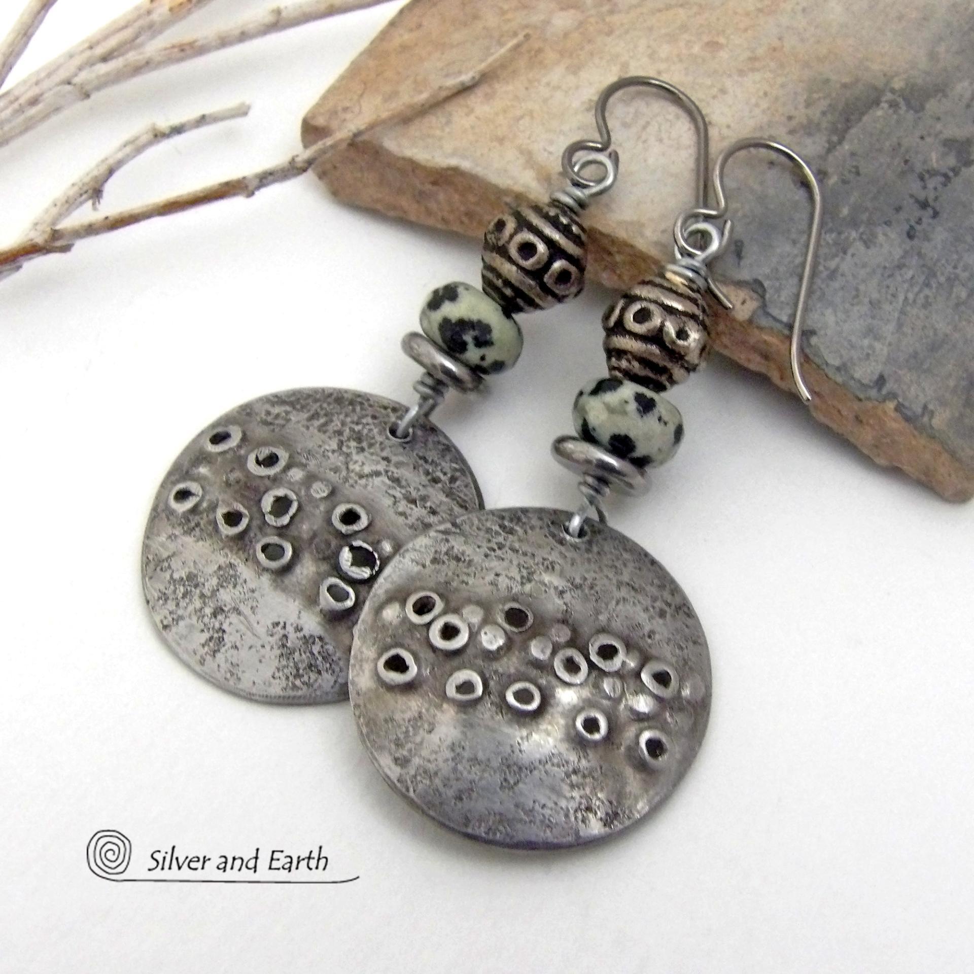 These handcrafted silver pewter earrings have a rustic, hand textured design and are accented with natural dalmatian jasper gemstones, stainless steel and vintage silver tone metal beads. They have an earthy, edgy organic style that makes a unique statement.This type of jasper is known for its spotted pattern that resembles the Dalmatian breed of dog. The matrix consists of mineral inclusions of brown iron oxide, black tourmaline & other minerals which create the natural "spots" in the stone. Handmade in th