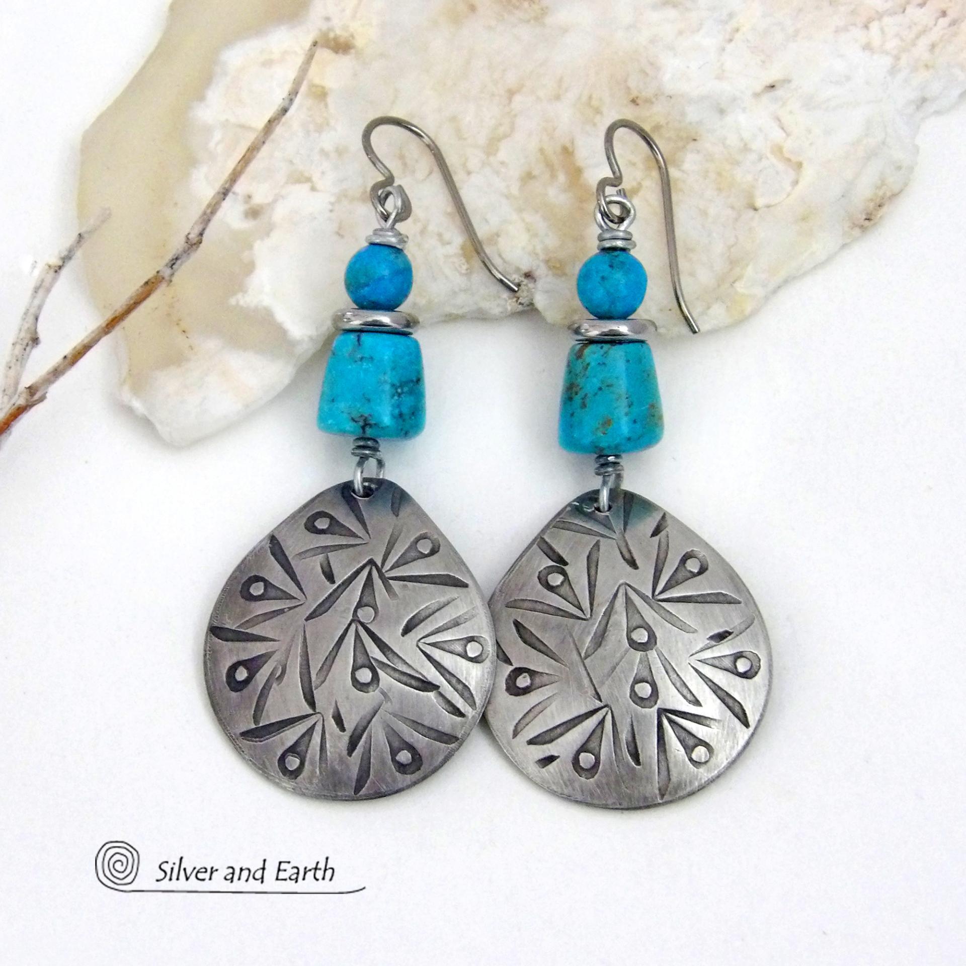 These handcrafted earrings feature silver pewter teardrop-shaped dangles with a hand stamped texture accented with natural turquoise stones and stainless steel spacer beads. They have a bold modern style with southwestern flair and will make a striking statement. They'll make a great gift for anyone that loves natural turquoise stones and southwest style jewelry. Handmade in the USA by Silver and Earth Jewelry, a New Mexico True Certified business. 