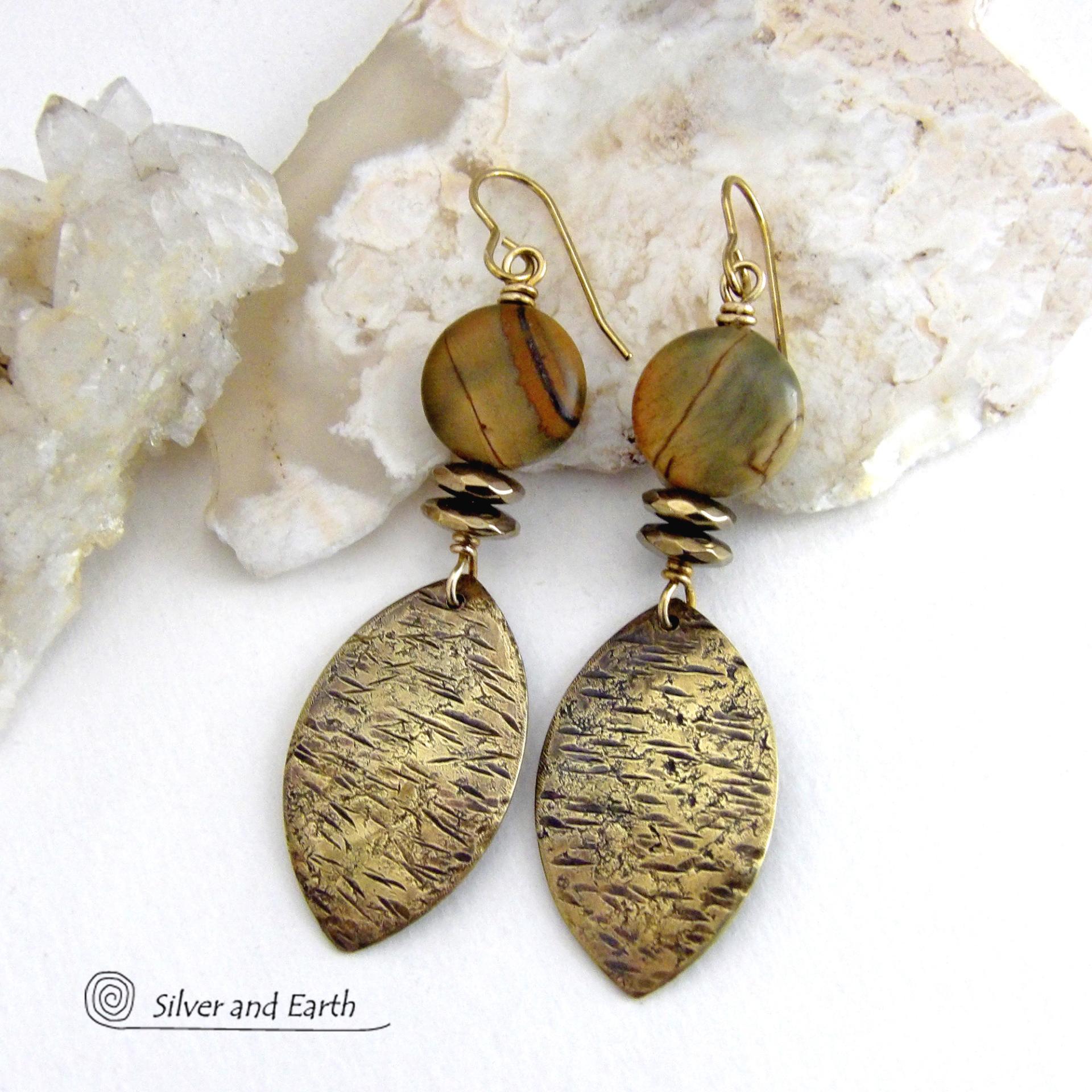 These handcrafted earrings feature textured gold brass dangles accented with natural Picasso jasper gemstones and hematite stone beads. The beads have an electroplated champagne gold tone finish which adds a touch of shimmer and shine. They have an earthy modern style that coordinates well with all wardrobe styles. Coordinating necklace is available and sold separately.