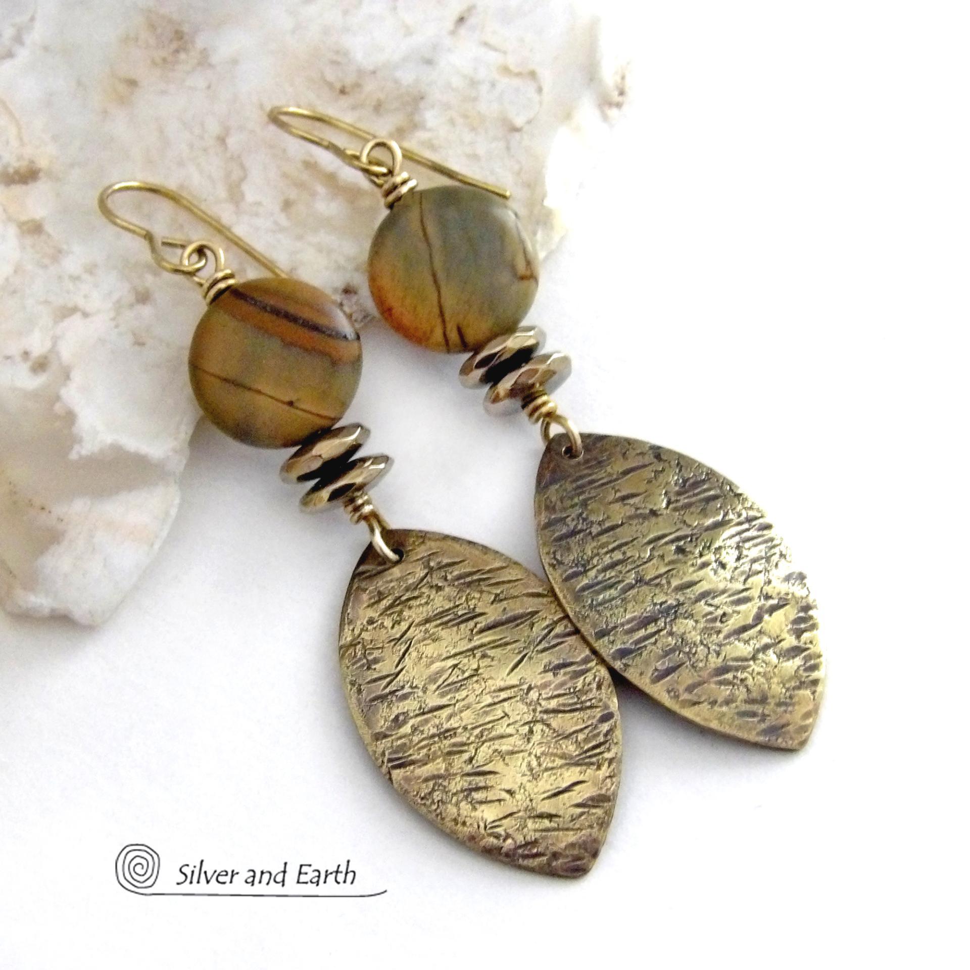 These handcrafted earrings feature textured gold brass dangles accented with natural Picasso jasper gemstones and hematite stone beads. The beads have an electroplated champagne gold tone finish which adds a touch of shimmer and shine. They have an earthy modern style that coordinates well with all wardrobe styles. Coordinating necklace is available and sold separately.