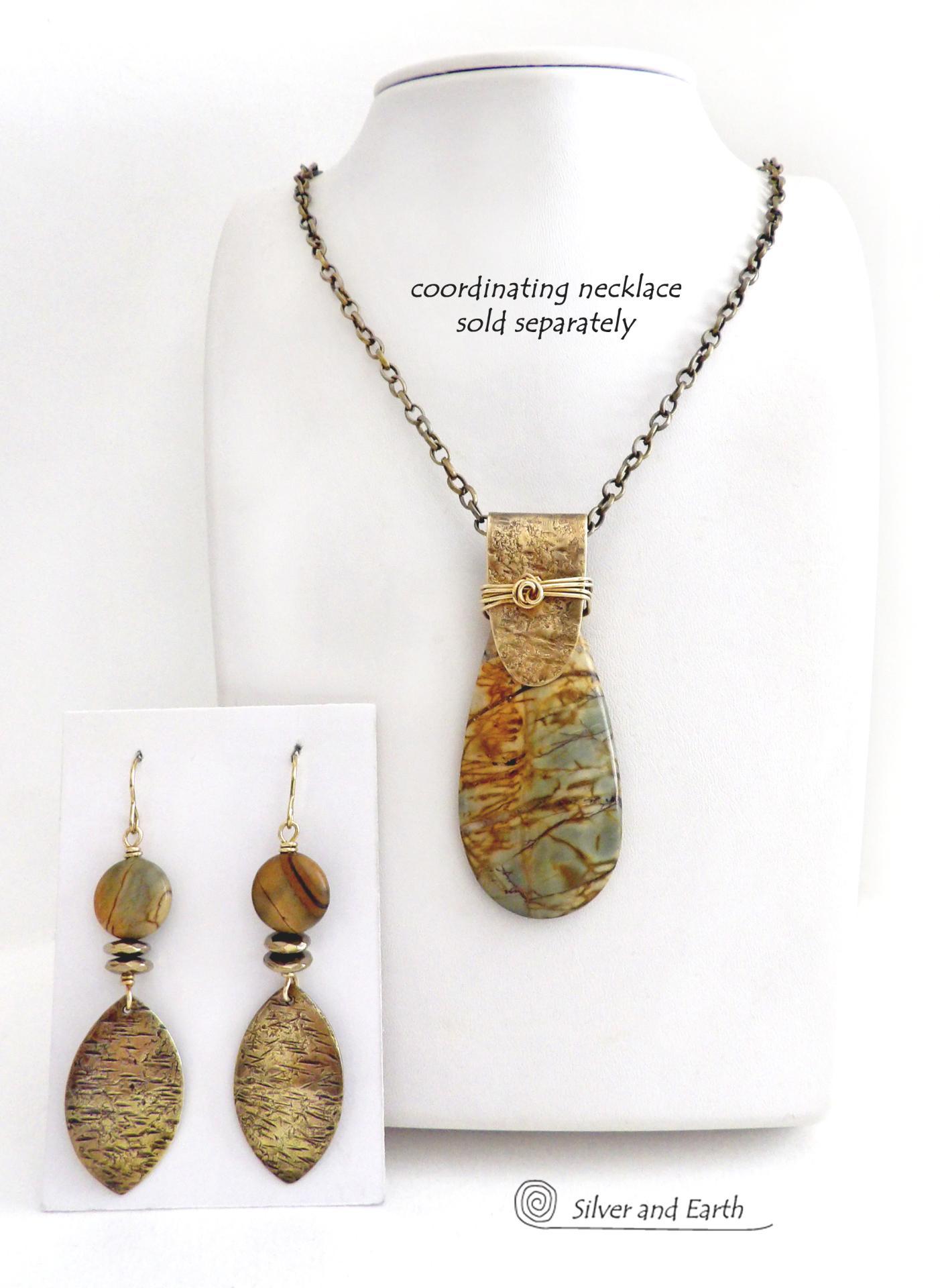 These handcrafted earrings feature textured gold brass dangles accented with natural Picasso jasper gemstones and hematite stone beads. The beads have an electroplated champagne gold tone finish which adds a touch of shimmer and shine. They have an earthy modern style that coordinates well with all wardrobe styles. Coordinating necklace is available and sold separately.