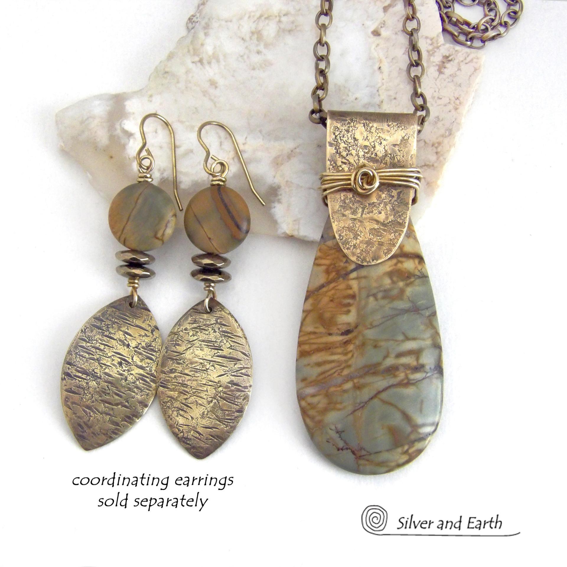 This handcrafted necklace features a natural Picasso jasper gemstone accented with a gold brass bail. The stone has a beautiful matrix with earthy hues of soft yellow, light mossy green and brown streaks. It has an earthy, modern style that coordinates beautifully with all wardrobe types. Unique and one of a kind, it makes a great gift for a natural stone lover - or a nice addition to your own jewelry collection. Comes on a 20" antiqued brass chain with lobster claw closure. 