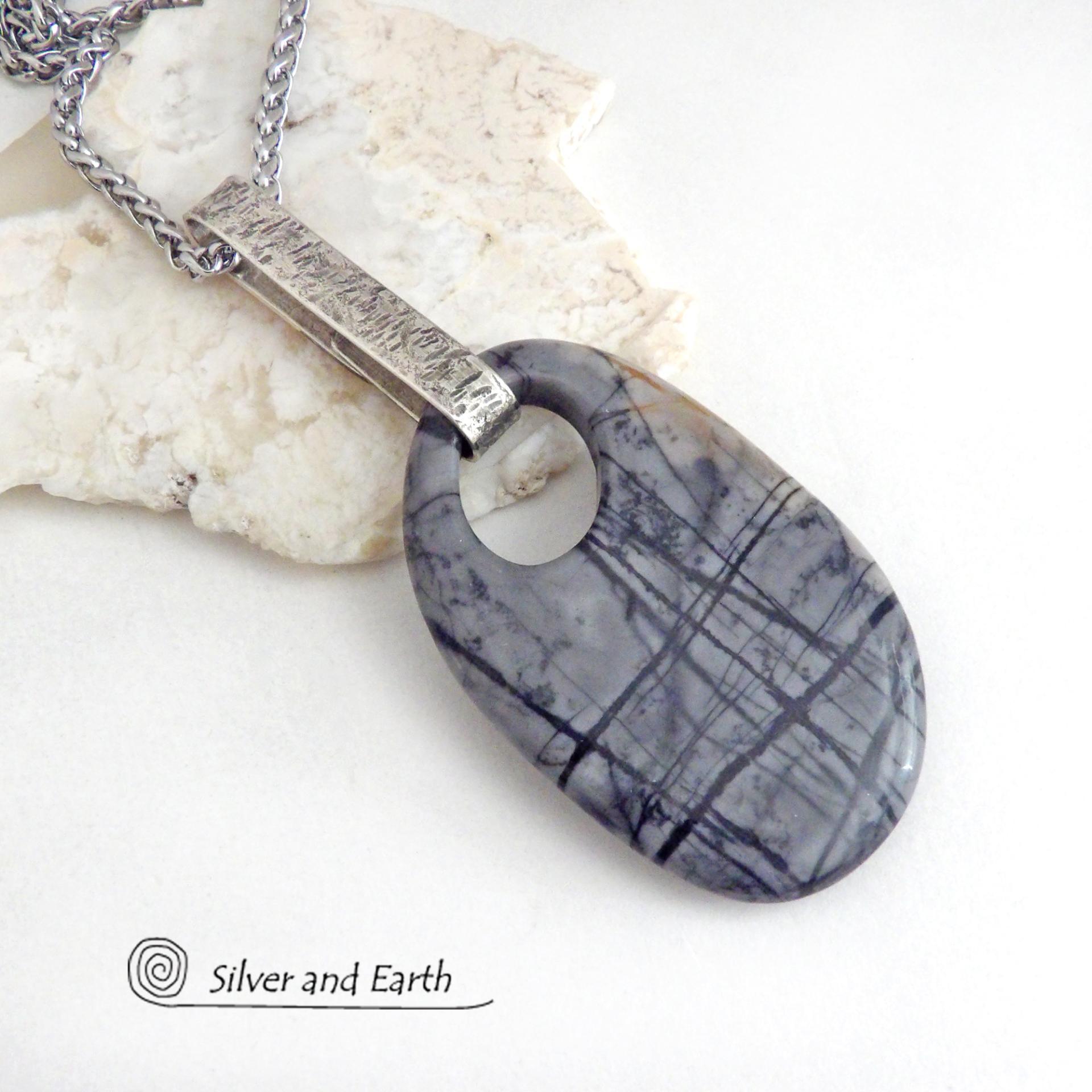 This one-of-a-kind necklace features a gorgeous natural Picasso marble gemstone accented with a hand forged sterling silver bail with a lightly hammered organic texture. The stone has earth tone shades of black, grey and some brown with an interesting matrix of abstract lines. This semiprecious stone is found only in southwest Utah. Makes a great gift for a natural stone lover - or a nice addition to your own jewelry wardrobe.