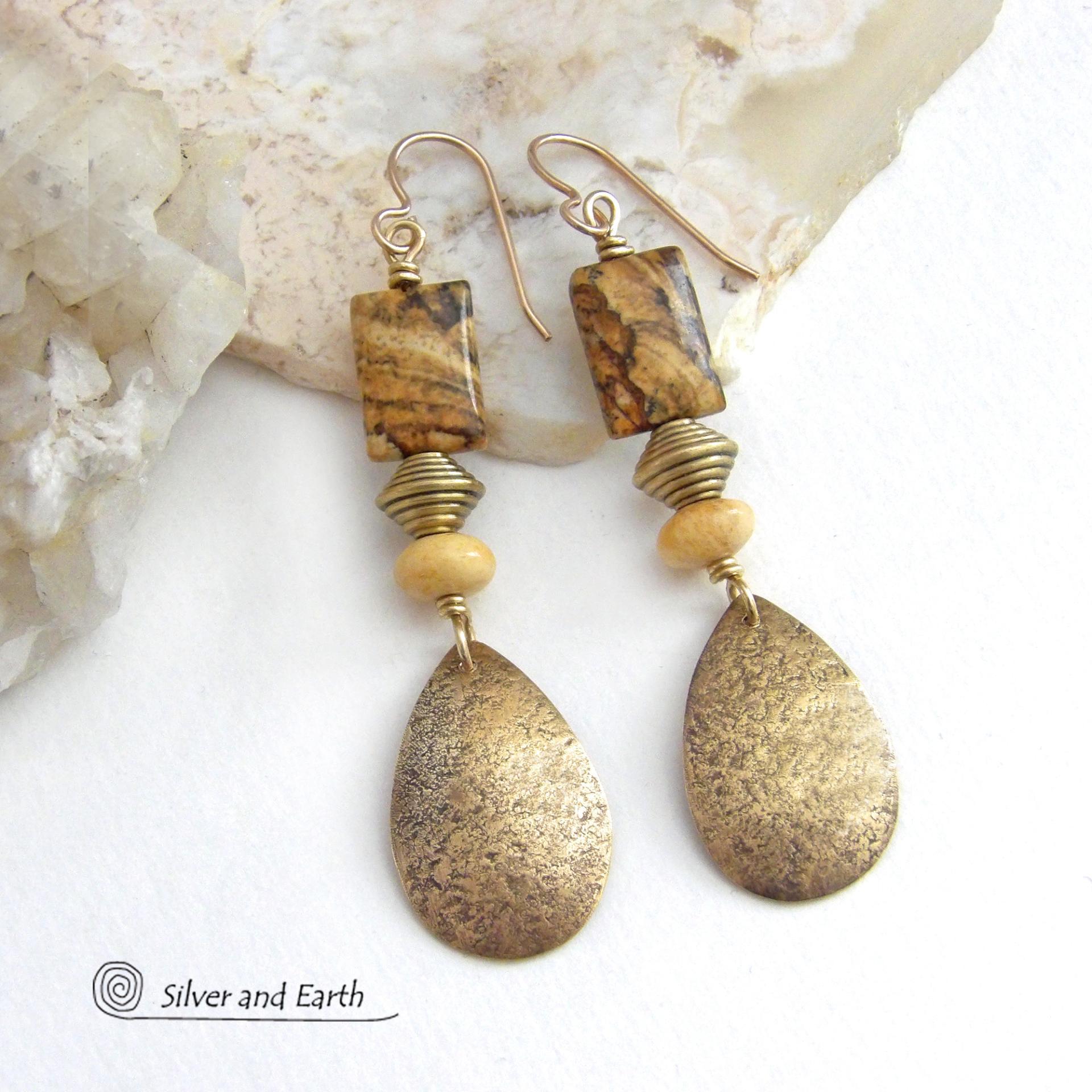 These handcrafted earrings feature gold brass teardrop dangles with a lightly hammered organic texture accented with natural picture jasper stones, brass and fossilized beige coral beads. They have an earthy natural style that coordinates beautifully with all wardrobe styles. Earrings have a coordinating necklace sold separately. Handmade in the USA by Silver and Earth Jewelry.