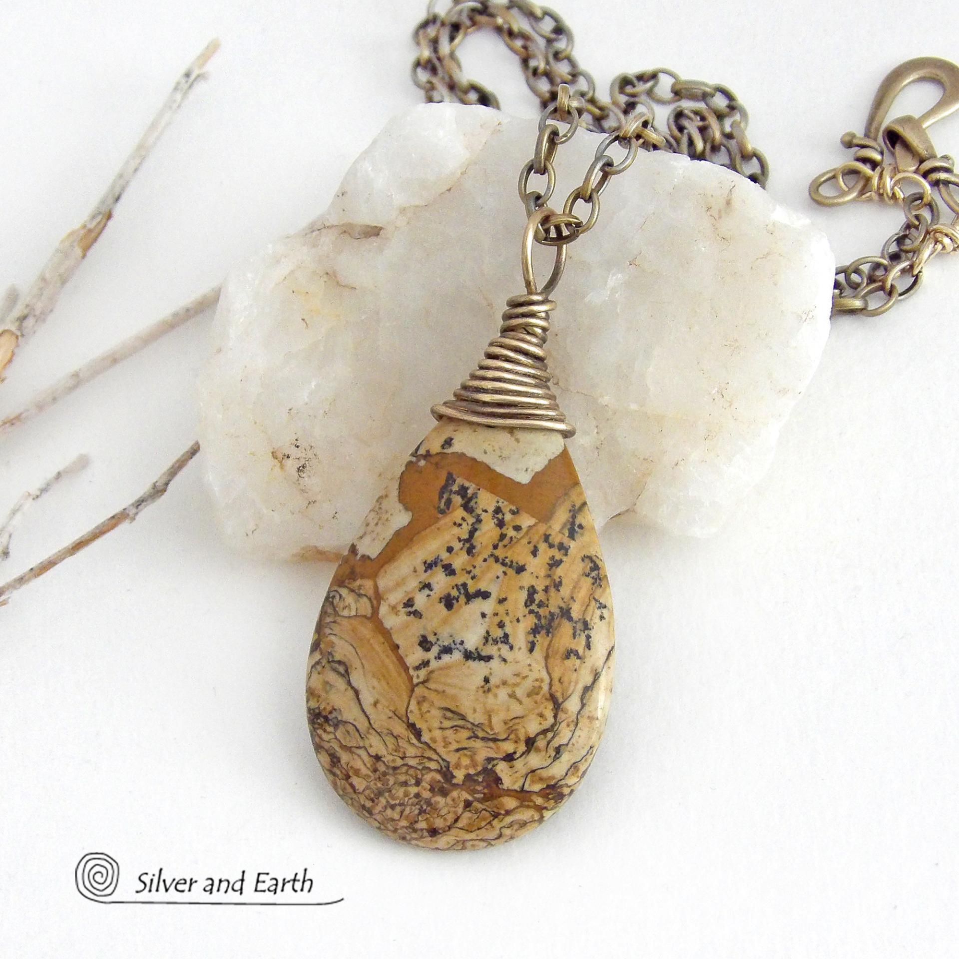 This one-of-a-kind necklace features a natural picture jasper stone wrapped in gold brass wire. The stone has an interesting matrix pattern with earthy hues of brown, tan and black. It has an earthy, simple style that coordinates beautifully with all wardrobe styles. It makes a great gift for a natural stone lover - or a nice addition to your own jewelry collection. Handmade in the USA by Silver and Earth Jewelry. Coordinating earrings sold separately.