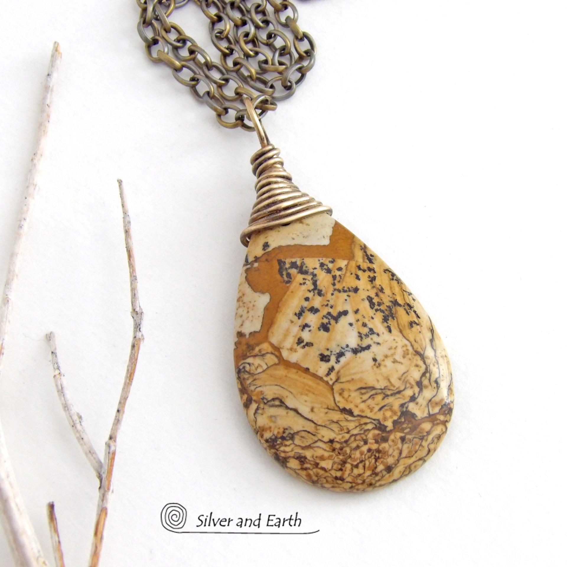 This one-of-a-kind necklace features a natural picture jasper stone wrapped in gold brass wire. The stone has an interesting matrix pattern with earthy hues of brown, tan and black. It has an earthy, simple style that coordinates beautifully with all wardrobe styles. It makes a great gift for a natural stone lover - or a nice addition to your own jewelry collection. Handmade in the USA by Silver and Earth Jewelry. Coordinating earrings sold separately.