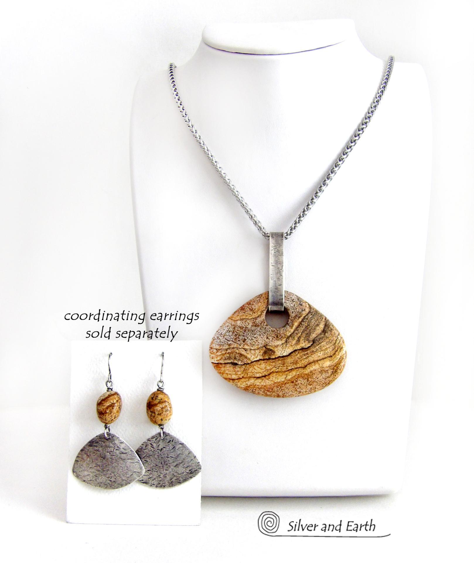 This handcrafted necklace features a large, chunky natural picture jasper stone accented with a handcrafted sterling silver bail. The stone has a beautiful natural pattern in various shades of brown, beige and gray. Big and bold, this necklace is a real one-of-a-kind statement piece - perfect for anyone that loves natural stones! It's reversible and can be worn on either side. Coordinating earrings sold separately. Handmade in the USA by Silver and Earth Jewelry.