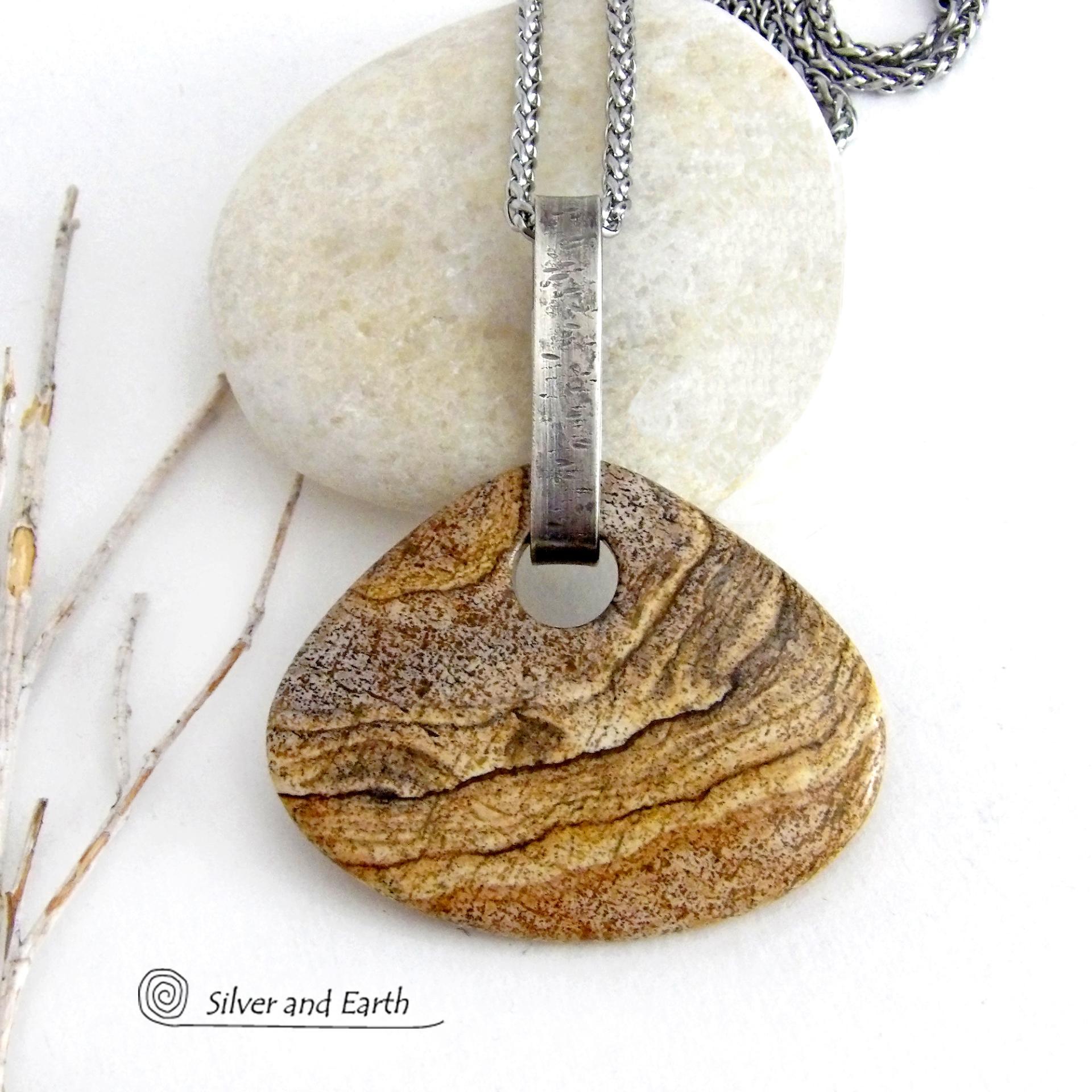 This handcrafted necklace features a large, chunky natural picture jasper stone accented with a handcrafted sterling silver bail. The stone has a beautiful natural pattern in various shades of brown, beige and gray. Big and bold, this necklace is a real one-of-a-kind statement piece - perfect for anyone that loves natural stones! It's reversible and can be worn on either side. Coordinating earrings sold separately. Handmade in the USA by Silver and Earth Jewelry.