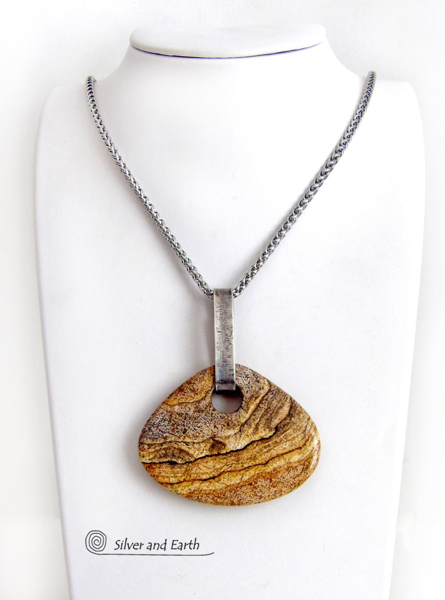 This handcrafted necklace features a large, chunky natural picture jasper stone accented with a handcrafted sterling silver bail. The stone has a beautiful natural pattern in various shades of brown, beige and gray. Big and bold, this necklace is a real one-of-a-kind statement piece - perfect for anyone that loves natural stones! It's reversible and can be worn on either side. Coordinating earrings sold separately. Handmade in the USA by Silver and Earth Jewelry.