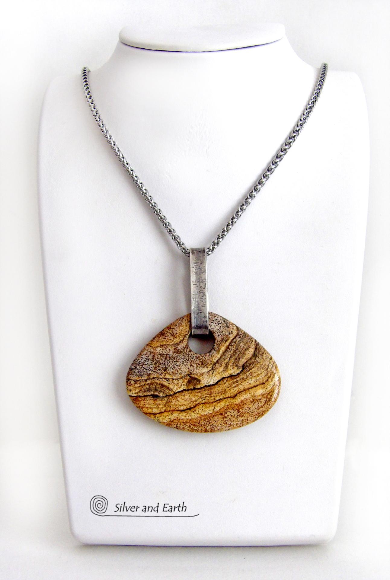 This handcrafted necklace features a large, chunky natural picture jasper stone accented with a handcrafted sterling silver bail. The stone has a beautiful natural pattern in various shades of brown, beige and gray. Big and bold, this necklace is a real one-of-a-kind statement piece - perfect for anyone that loves natural stones! It's reversible and can be worn on either side. Coordinating earrings sold separately. Handmade in the USA by Silver and Earth Jewelry.