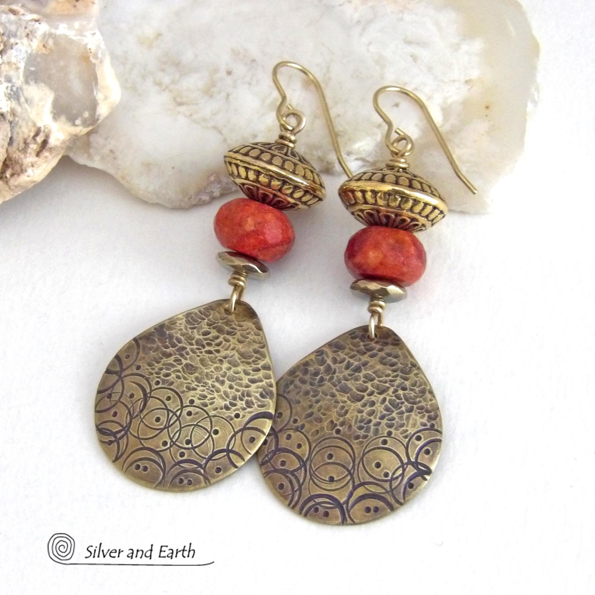 These handcrafted gold brass earrings have a hand stamped and hammered texture and are accented with faceted red coral, brass tribal style beads and faceted hematite stone beads with an electroplated champagne gold tone finish. Big and bold, they have a modern boho chic vibe with a tribal flair that makes a striking statement. Perfect for women that love to wear unique and eye-catching artisan handcrafted jewelry. Handmade in the USA by Silver and Earth Jewelry.