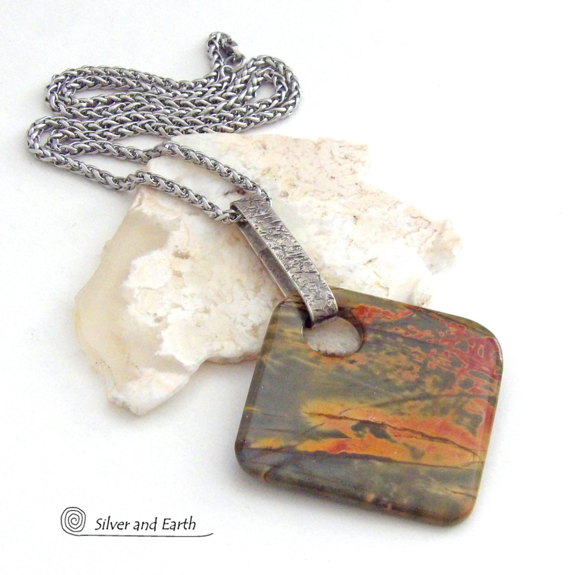 This one-of-a-kind necklace features a natural red creek jasper stone accented with a hand forged sterling silver bail. The stone has a beautiful natural pattern in earthy hues of mossy greens, brick red and orange. Great colors for your fall wardrobe! It's reversible and can be worn on either side. (See all photos for alternate sides). It will make a great gift for anyone that loves natural stones! The design is unisex so it could be worn by a man or woman.