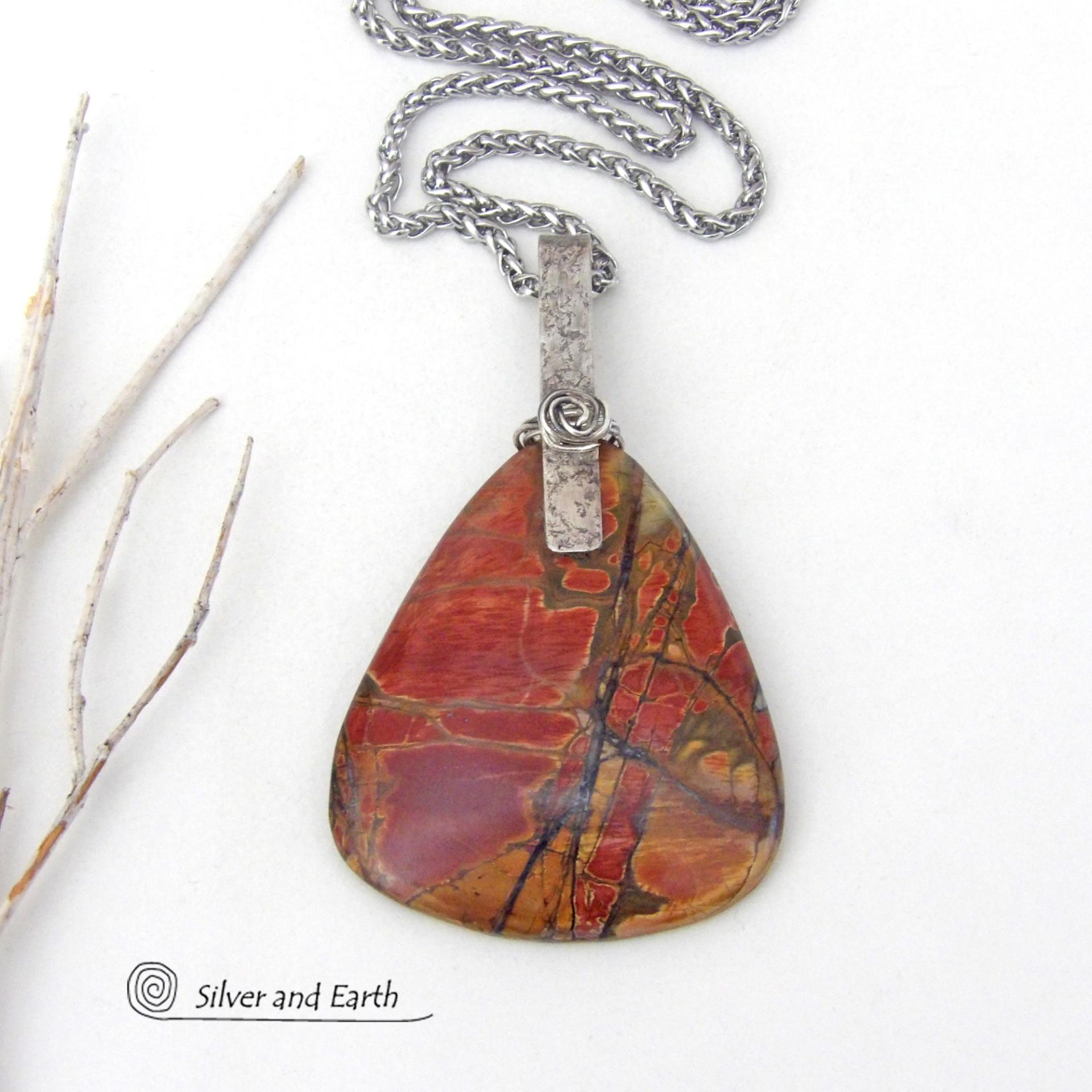 This one-of-a-kind necklace features a large stunning red creek jasper stone accented with a handcrafted sterling silver bail. The stone has a natural pattern in beautiful earthy shades of brick red, orange and green with subtle hints of golden yellow. Big and bold, this necklace is a real statement piece - perfect for anyone that loves natural stones!