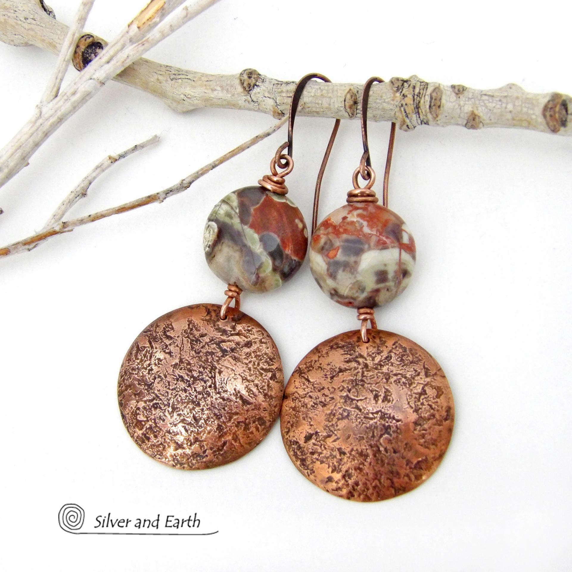 These handcrafted earrings feature natural rhyolite jasper stones accented with copper dangles with a rustic hammered texture. The stones have a natural earthy pattern with various shades of green, rusty orange, brown and cream. They have a casual and earthy style and will make a great gift for a natural stone lover - or a nice addition to your own jewelry wardrobe. Your choice of ear wires. Coordinating necklace sold separately. Handmade in the USA by Silver and Earth Jewelry.