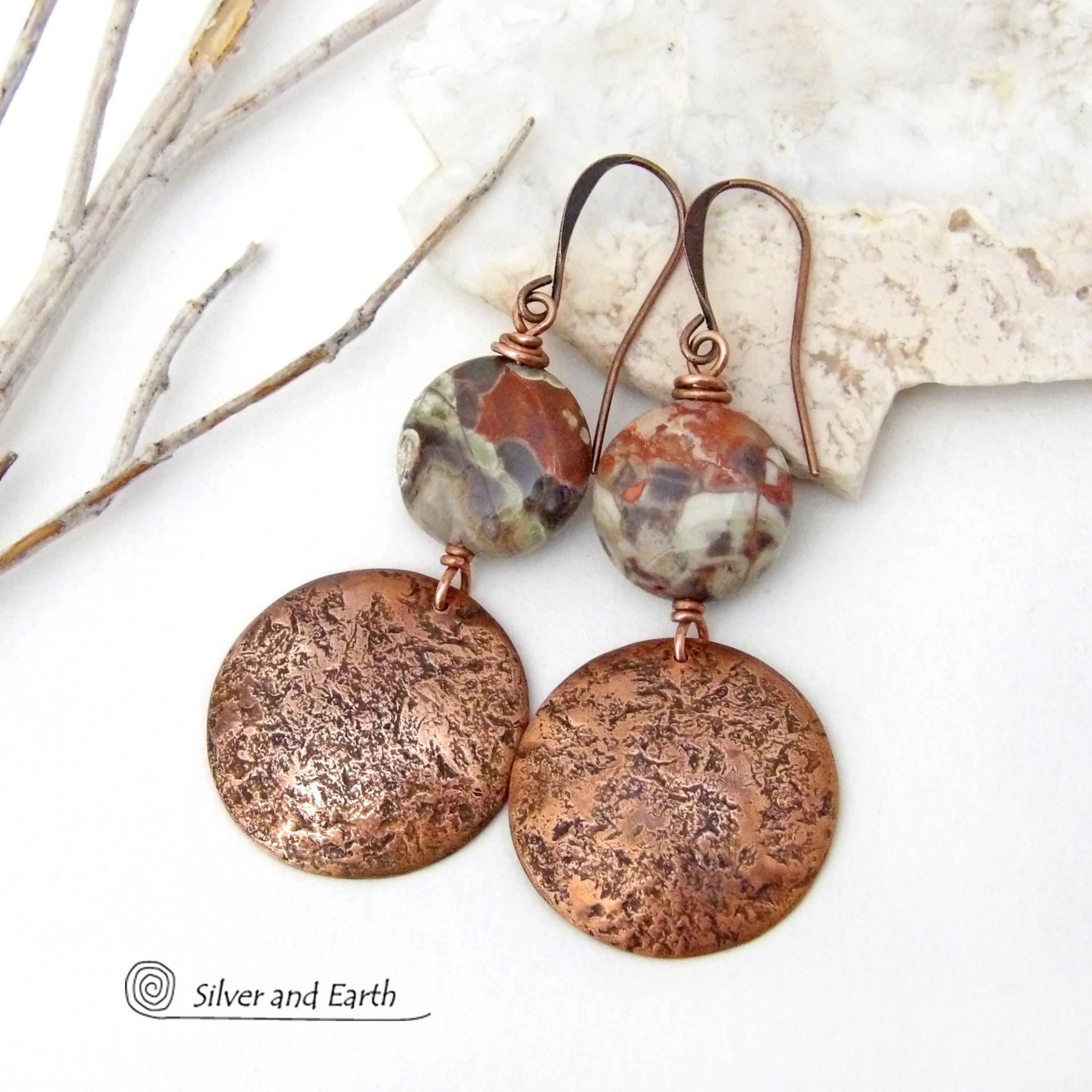 These handcrafted earrings feature natural rhyolite jasper stones accented with copper dangles with a rustic hammered texture. The stones have a natural earthy pattern with various shades of green, rusty orange, brown and cream. They have a casual and earthy style and will make a great gift for a natural stone lover - or a nice addition to your own jewelry wardrobe. Your choice of ear wires. Coordinating necklace sold separately. Handmade in the USA by Silver and Earth Jewelry.
